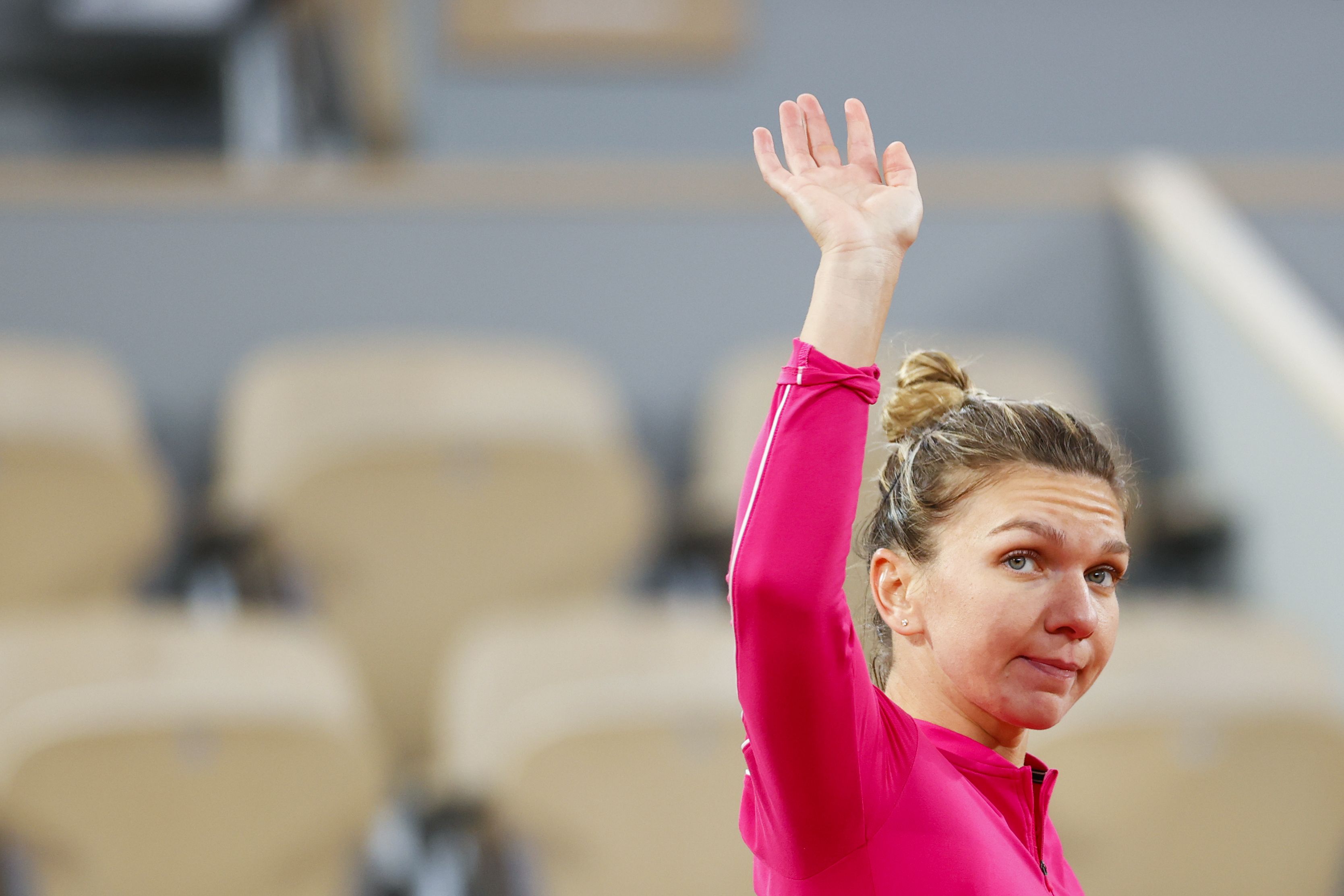 Simona Halep melambaikan tangan setelah kalah melawan Iga Swiatek dalam Prancis Terbuka.
