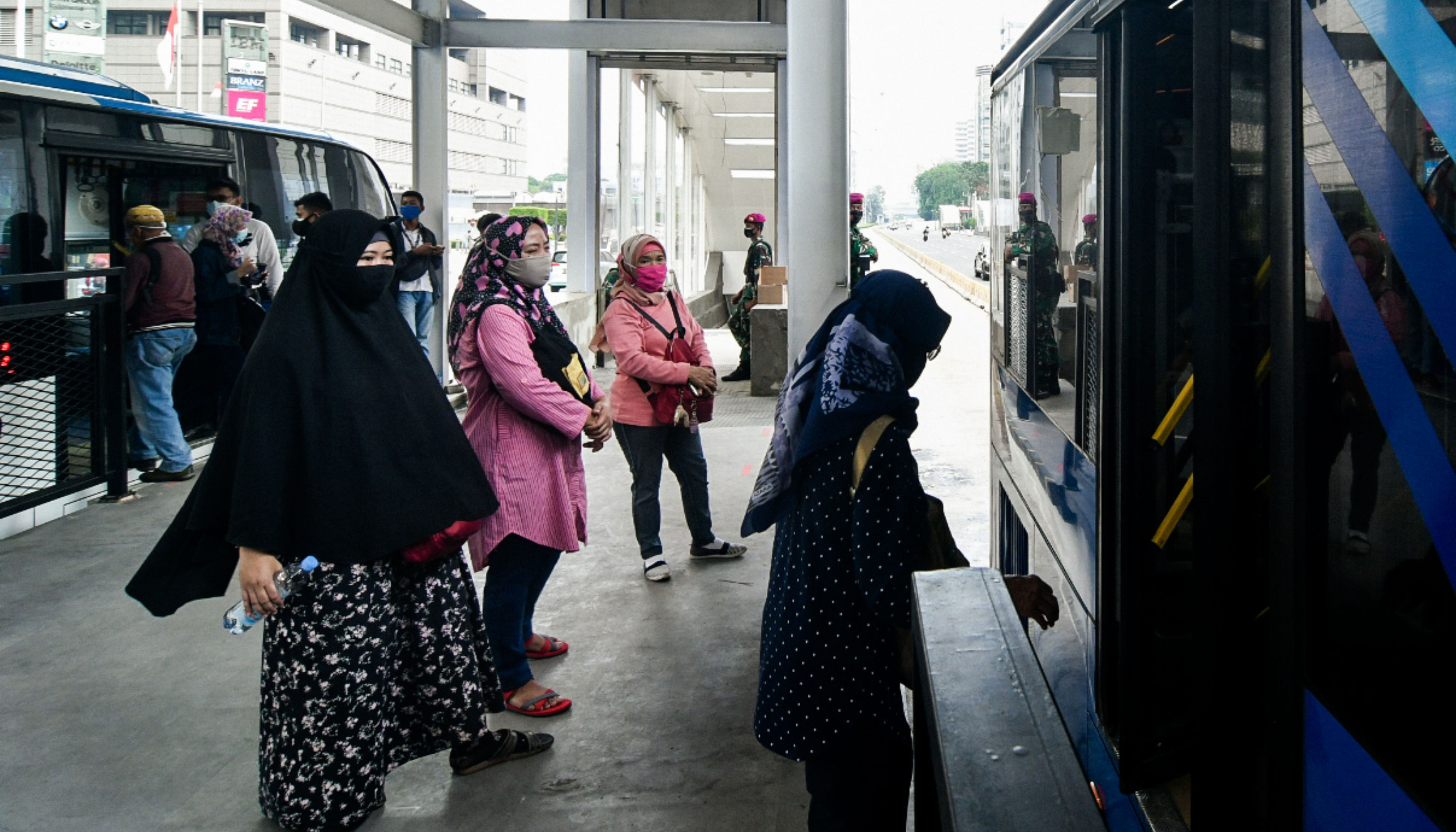 Penumpang antre masuk bus Trans-Jakarta di Halte Bundaran Hotel Indonesia, Jakarta.