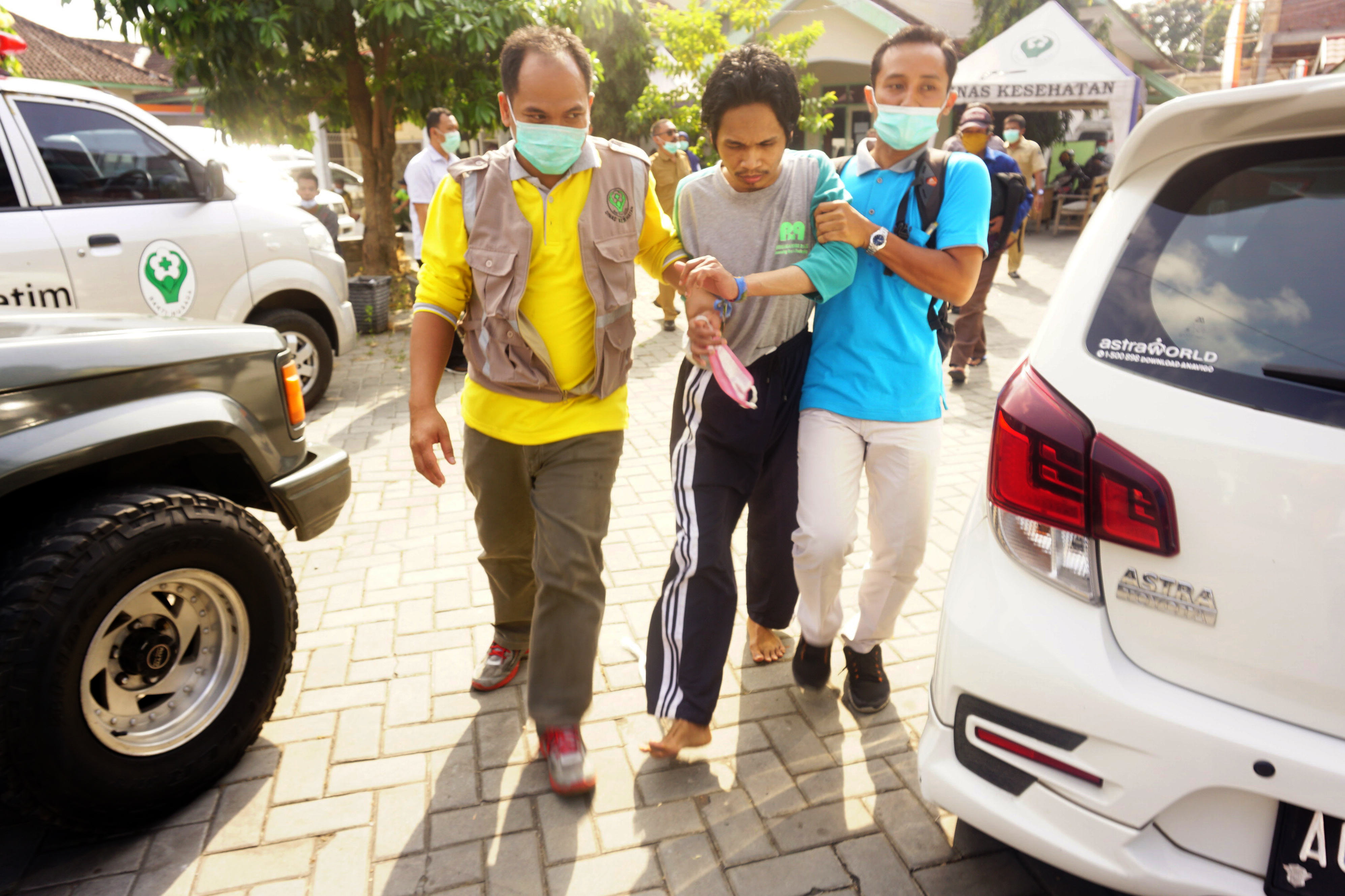 Petugas membawa penderita gangguan jiwa (ODGJ) menuju bus yang menunggu di halaman kantor Dinas Kesehatan Tulungagung.