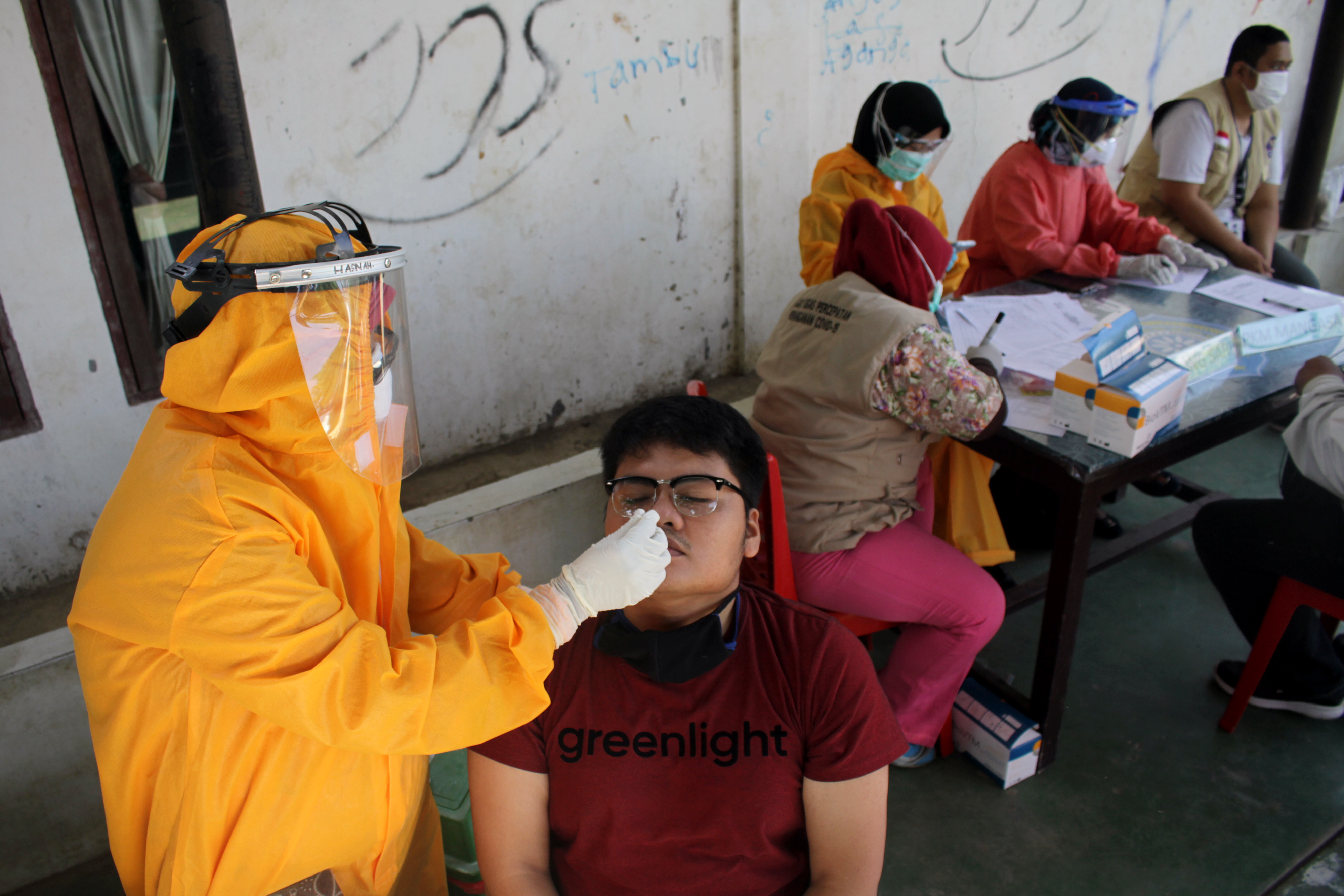 Tenaga medis melakukan tes usap terhadap warga di Kecamatan Rappocini, Makassar, Sulawesi Selatan, Jumat (23/10/2020).