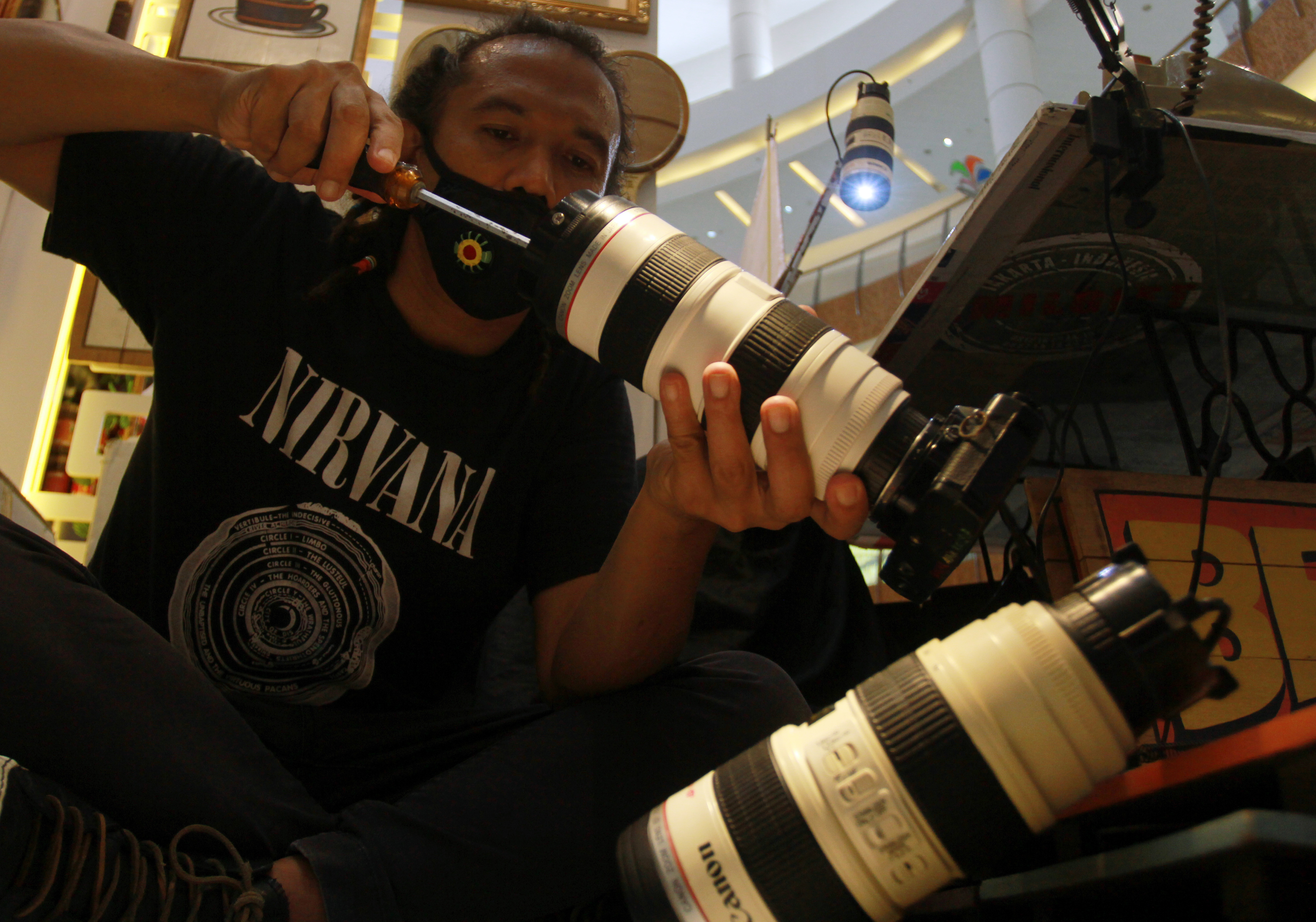  Perajin menyelesaikan pembuatan lampu meja yang terbuat dari lensa bekas dan replika lensa di sebuah pameran Creative Culture Home. 