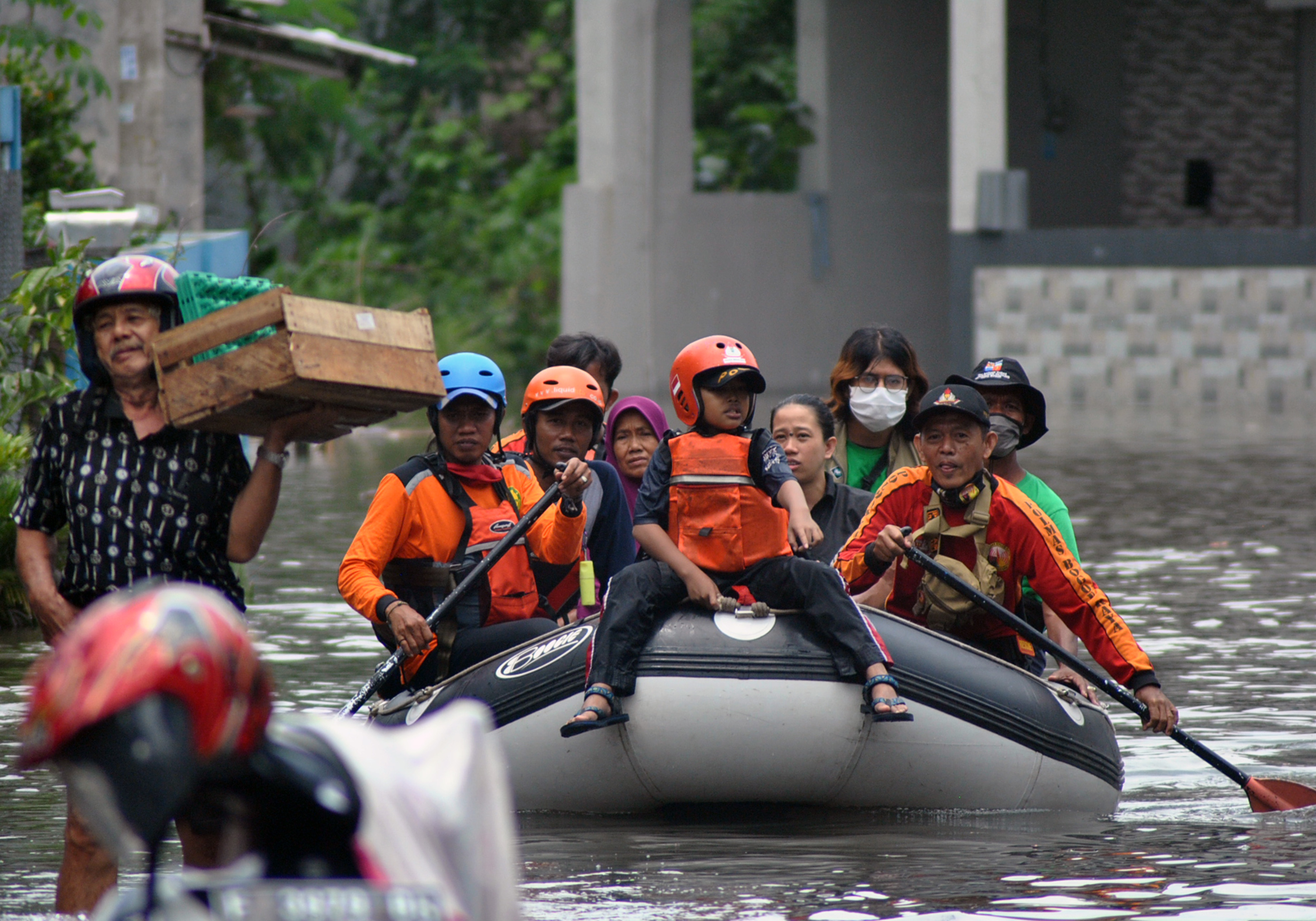  Petugas Polmas dan BPBD Kota Bogor mengevakuasi warga yang rumahnya terendam banjir,  Senin (26/10/2020)