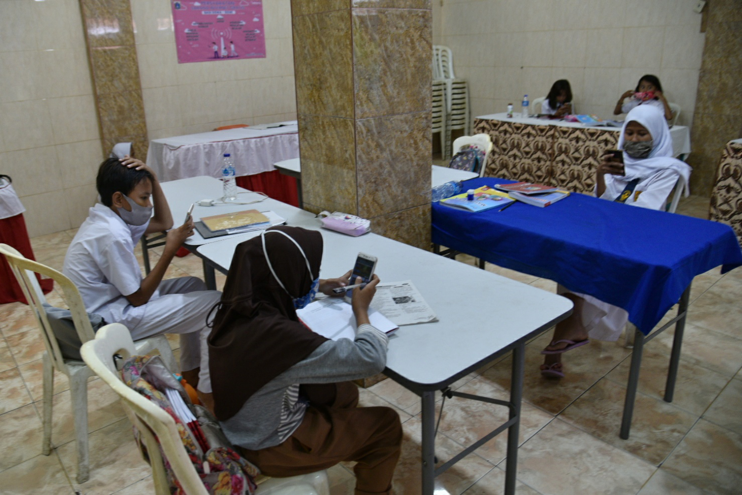 Sejumlah siswa SD belajar dengan menggunakan wifi gratis yang disediakan di Balai Warga Kelurahan Galur, Johar Baru, Jakarta Pusat.