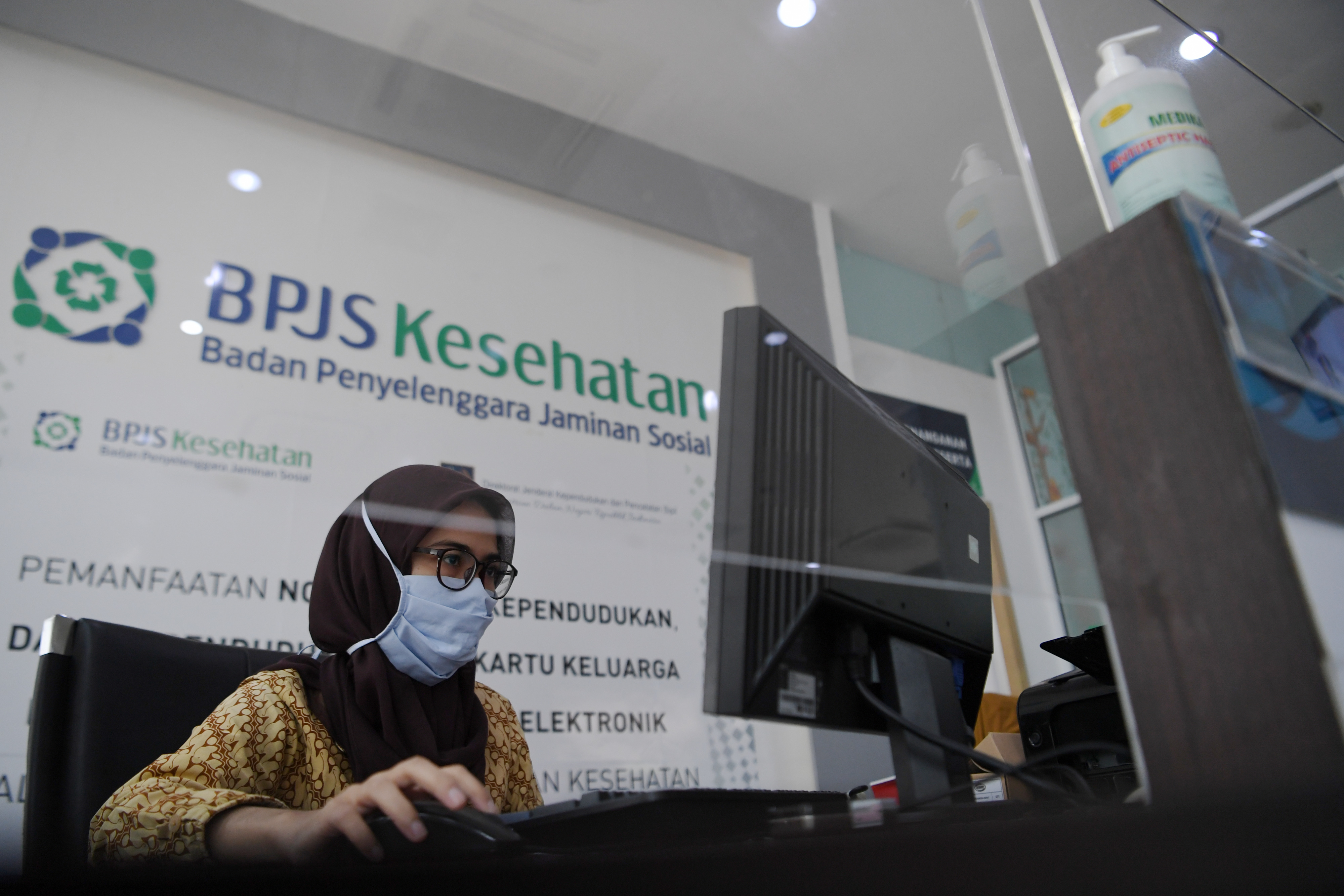Petugas melayani peserta BPJS Kesehatan dengan tanpa tatap muka di Kantor BPJS Kesehatan cabang Jakarta Selatan, Jakarta, Selasa (6/10).