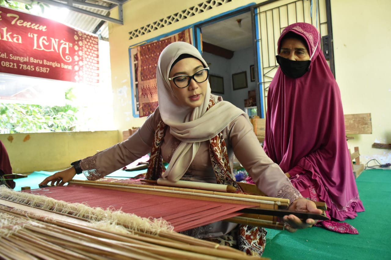 Ibu Melati mencoba menenun.