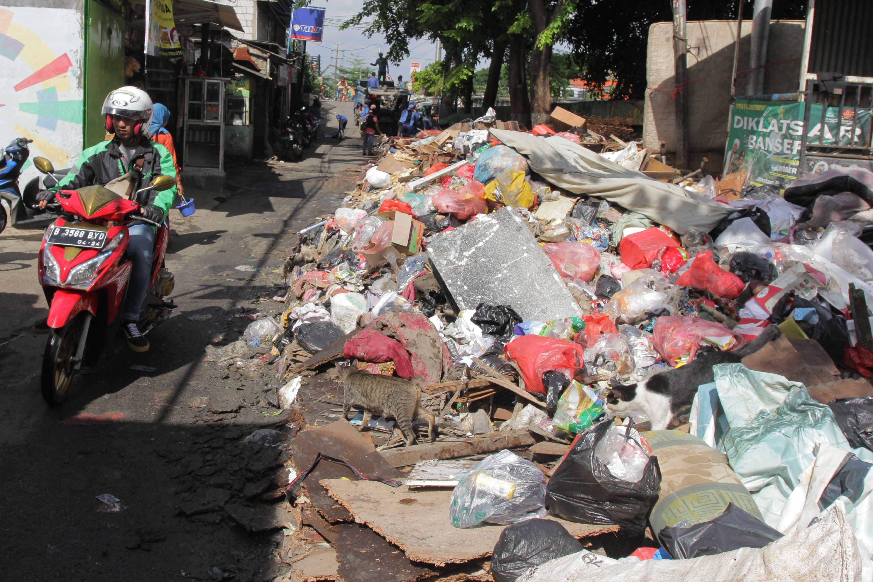 Sampah pasca-banjir terhampar di sepanjang jalan kawasan Rawa Buaya, Cengkareng, Jakarta Barat, Minggu (12/1/2020).