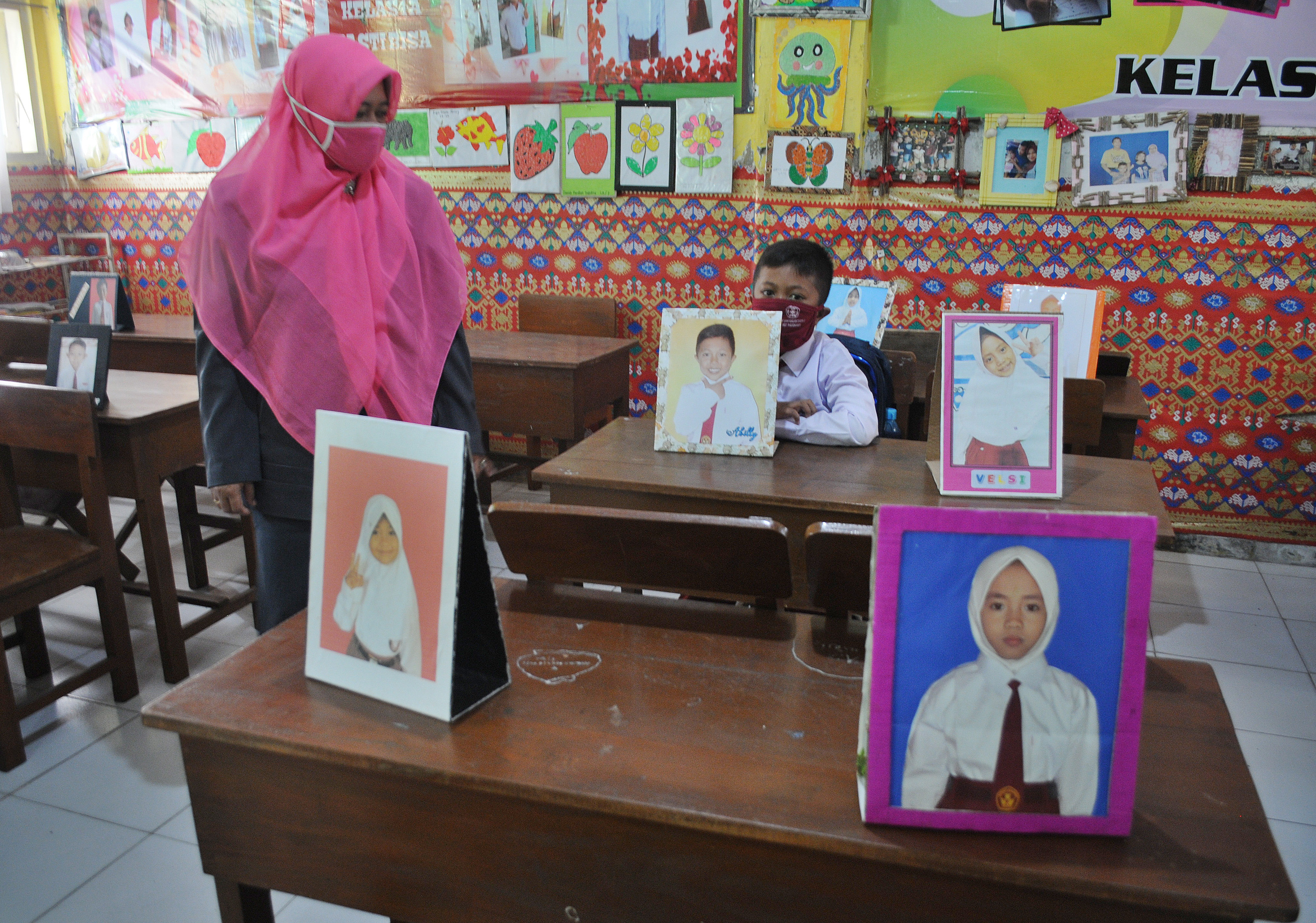 PEMBELAJARAN TATAP MUKA SD DI PAMEKASAN: Guru mengajar saat hari pertama Pembelajaran Tatap Muka (PTM) di SDN Lawangan Daya 2, Pamekasan, J