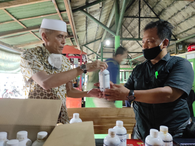 Tokoh masyarakat Solo Hasan Mukachela (kiri) membagikan suplemen probiotik kepada wartawan.