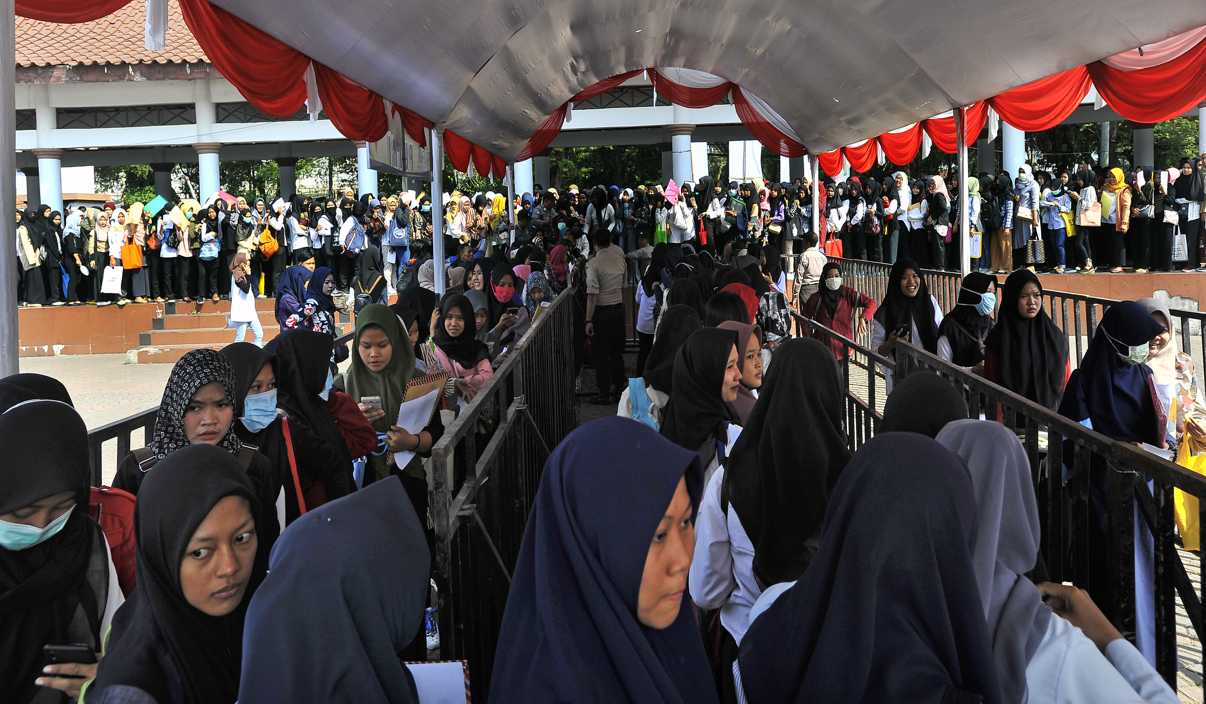  Pencari kerja antre menunggu giliran masuk ruang penerimaan lamaran di arena Bursa Kerja di Alun-alun Serang, Banten 2019.