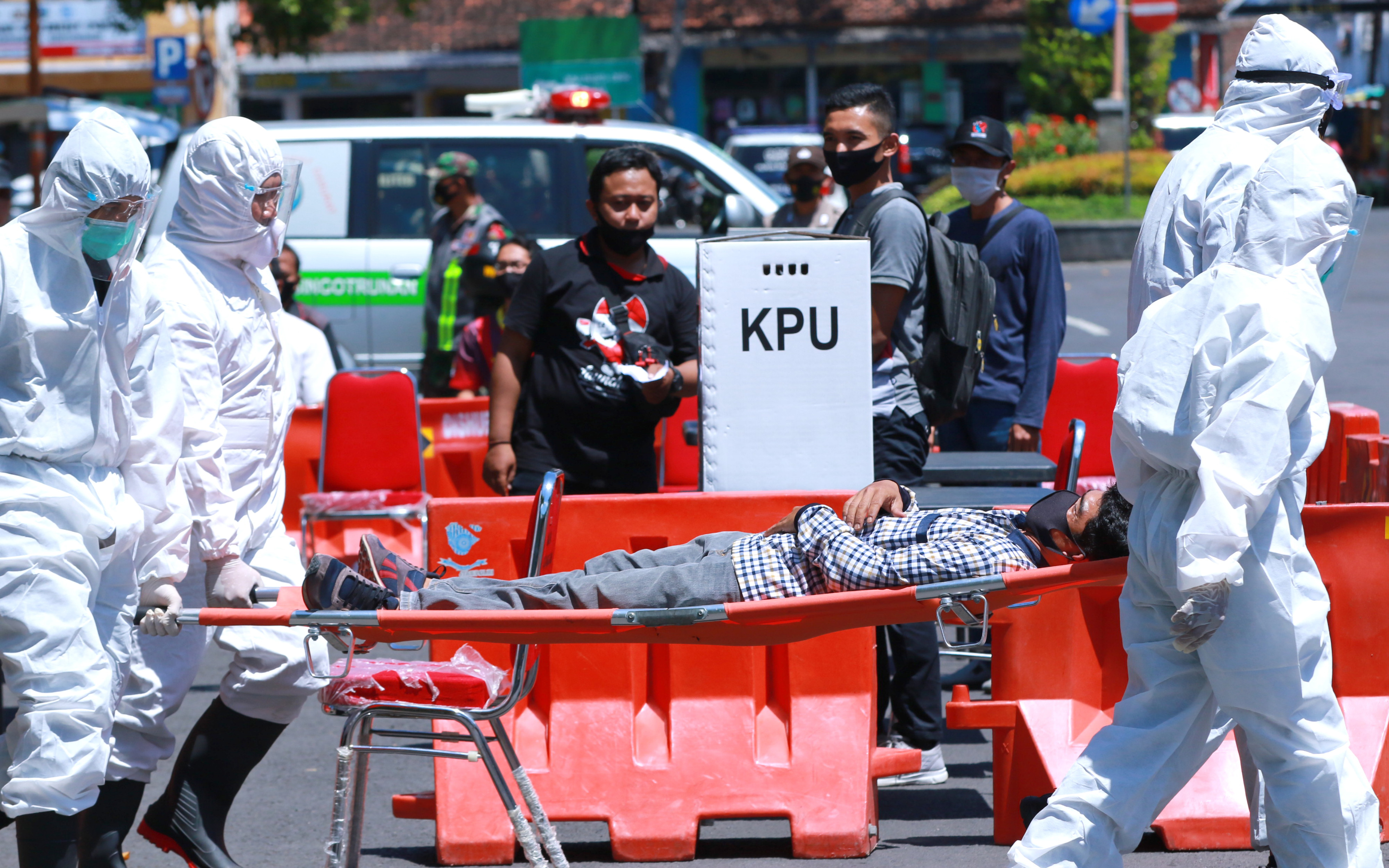 Petugas kesehatan mengangkat pemilih yang pingsan saat simulasi Pemilihan Kepala Daerah di Banyuwangi, Jawa Timur.