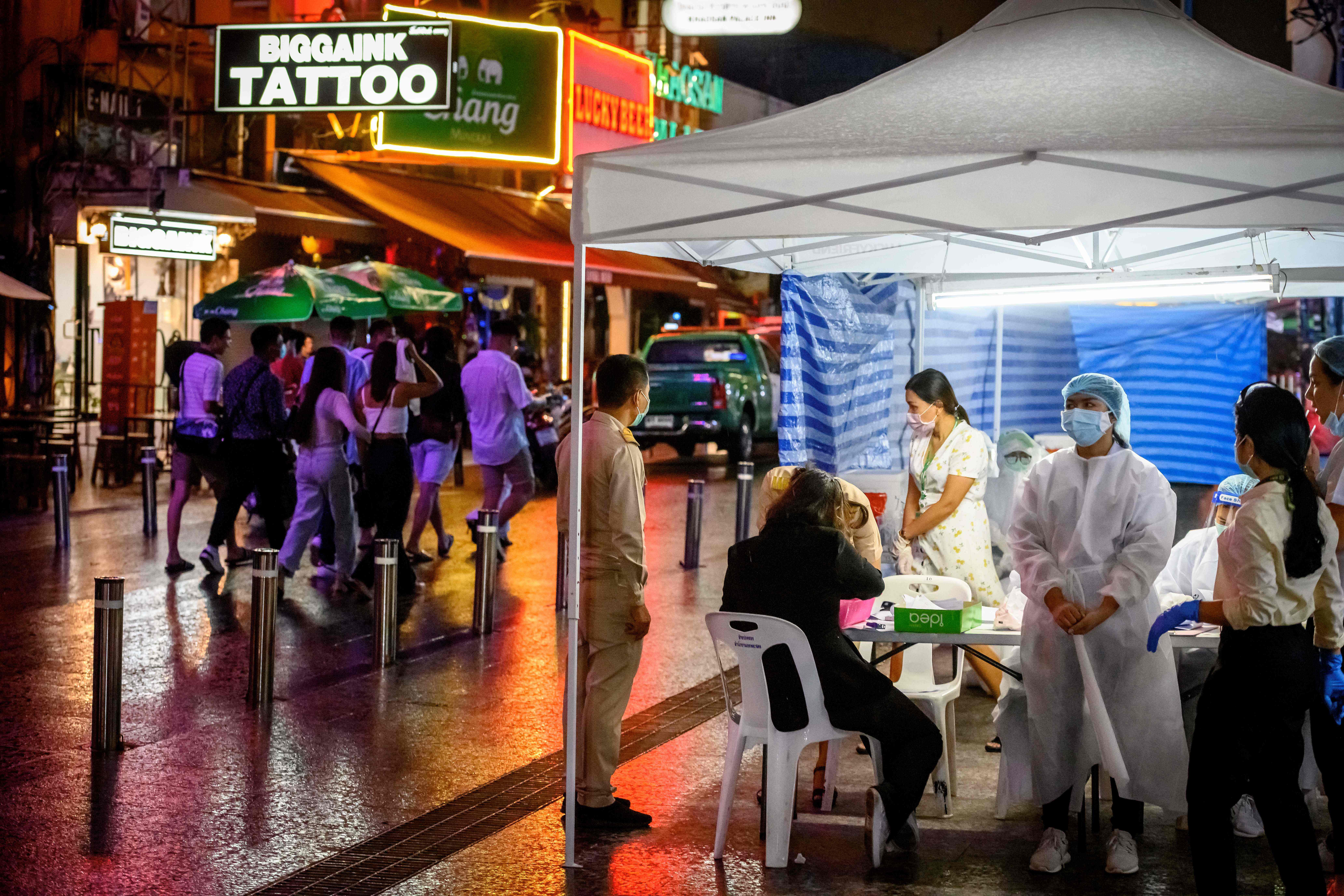 Petugas medis menunggu warga yang ingin melakukan tes covid-19 gratis di Bangkok.