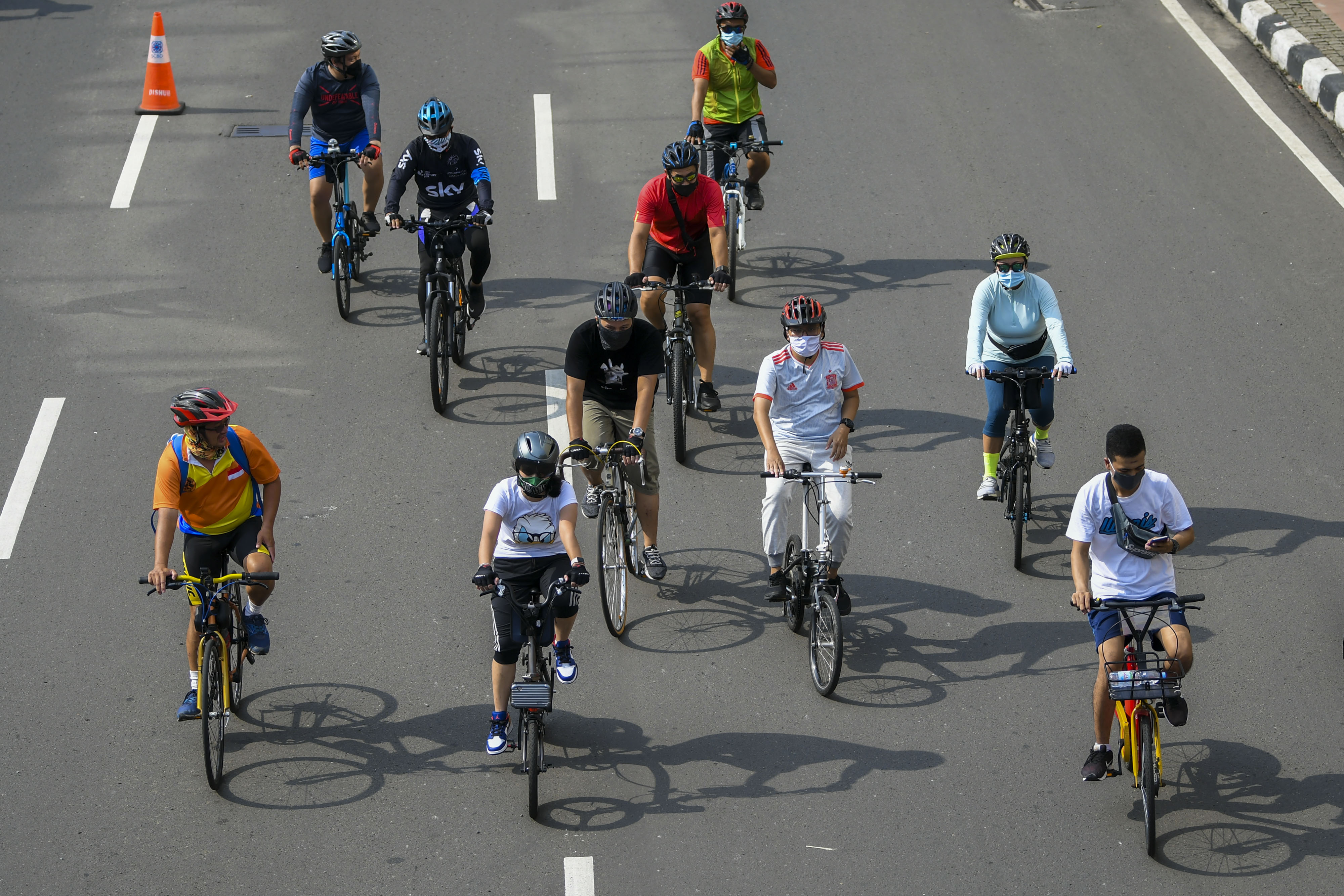 Warga bersepeda dengan memakai masker di kawasan Jalan MH Thamrin, Jakarta.