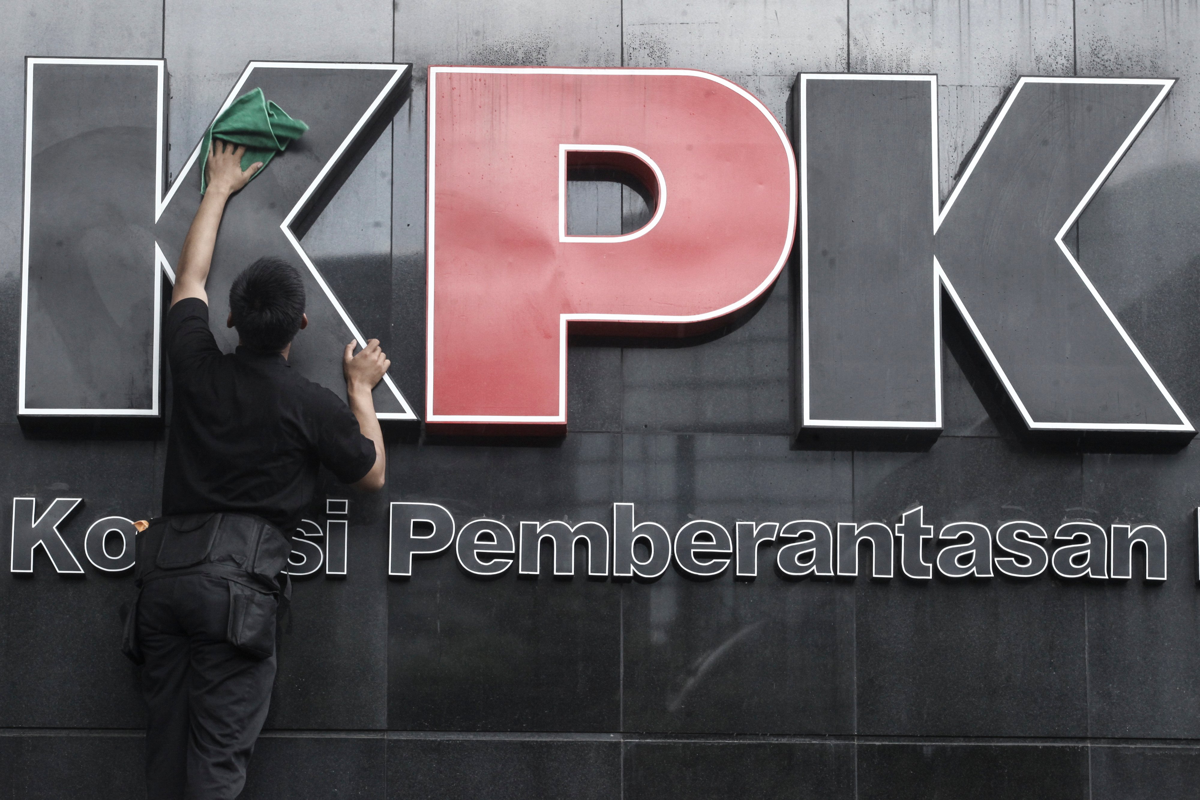 Pekerja membersihkan logo Komisi Pemberantasan Korupsi di gedung KPK, Jakarta.
