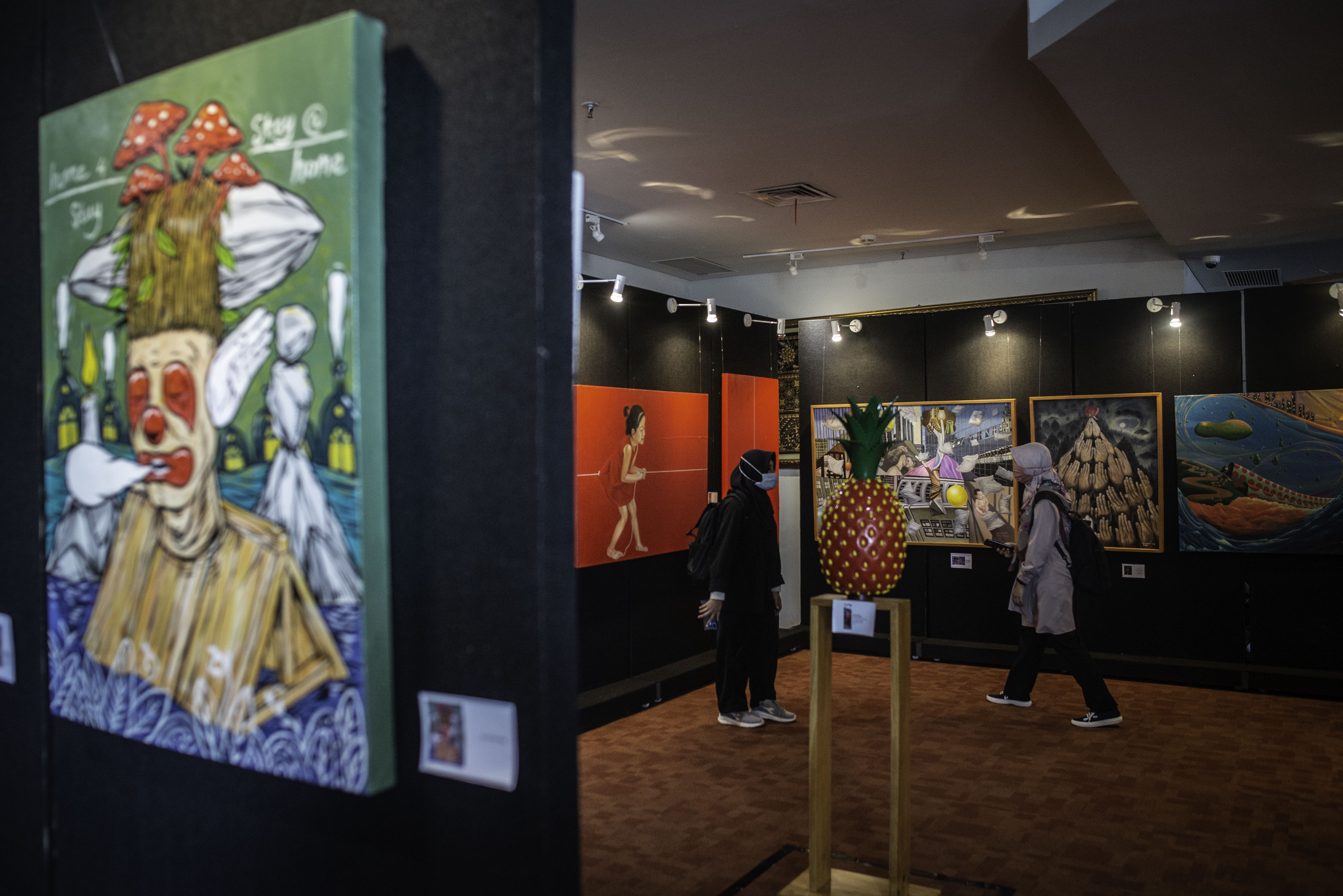 Pengunjung mengamati karya seni yang ditampilkan dalam pameran seni rupa di Perpustakaan Nasional, Jakarta.