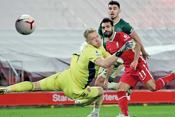 Gelandang Liverpool Mohamed Salah (kanan) mengecoh kiper Sheffi eld United Aaron Ramsdale sehingga bola menjebol gawang