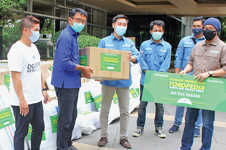 Ketua Yayasan Dompet Kemanusiaan Media Group (DKMG) Ali Sadikin (kedua dari kiri) menerima donasi dari penguna Tokopedia melalui Benihbaik.