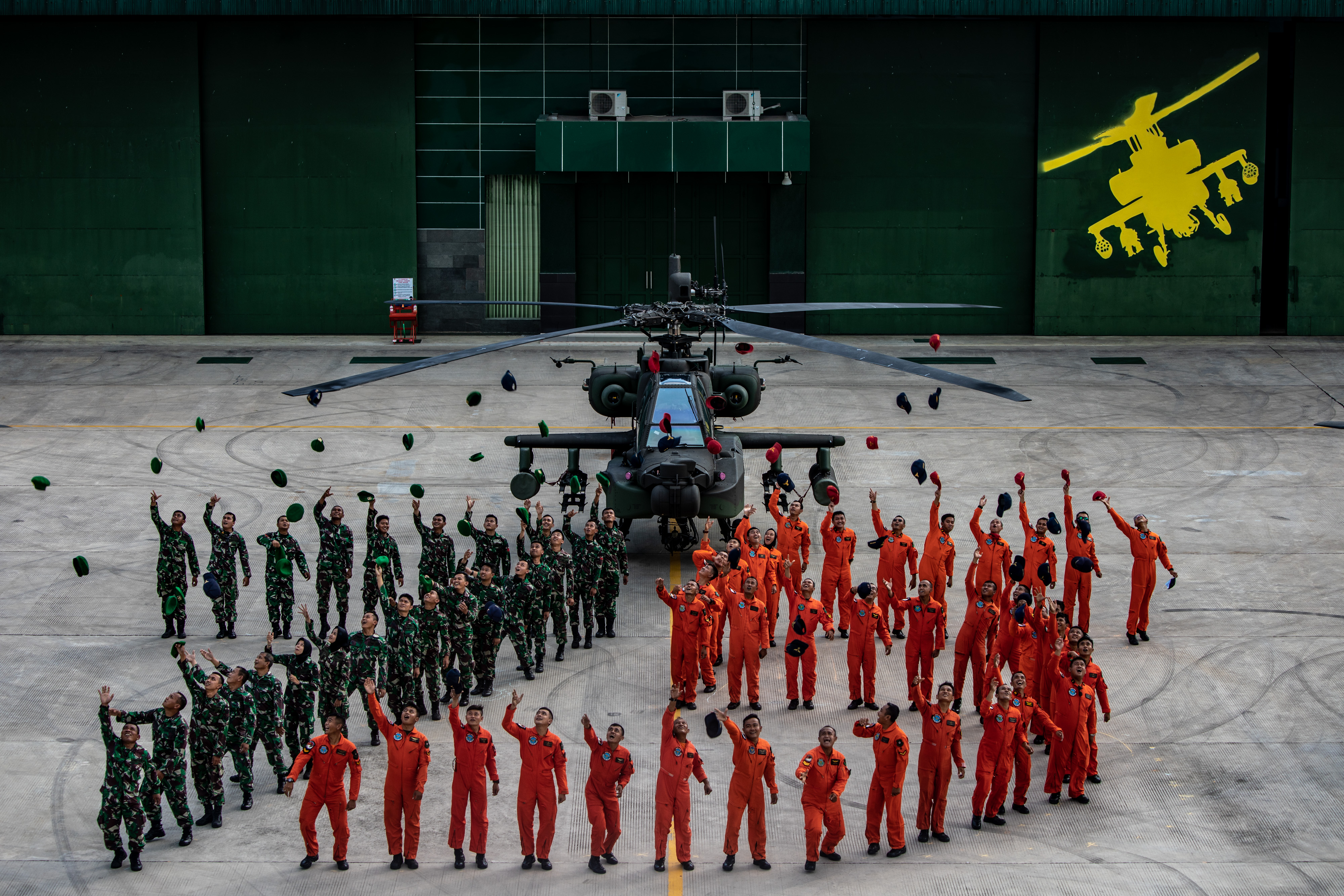  Prajurit TNI-AD dari Skadron-11/Serbu Puspenerbad melemparkan topi dan baret usai membentuk formasi angka 75 HUT TNI.