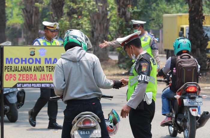 Petugas Polantas Polres Metropolitan Tangerang memeriksa kelengkapan surat-surat kendaraan bermotor