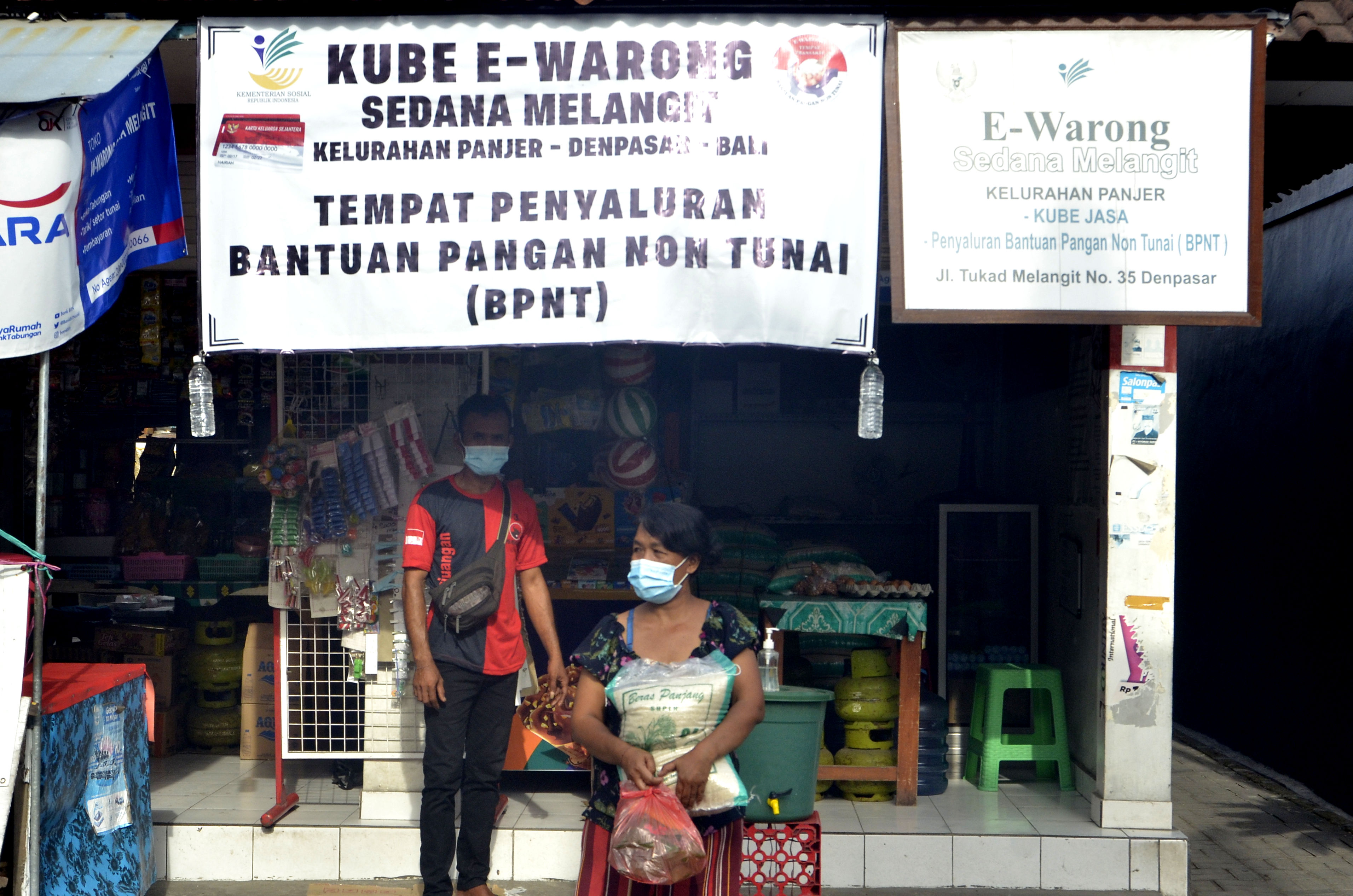 Warga membawa sembako yang dibeli di Kube E-Warong Sedana Melangit, Panjer, Denpasar, Bali, Selasa (27/10/2020).