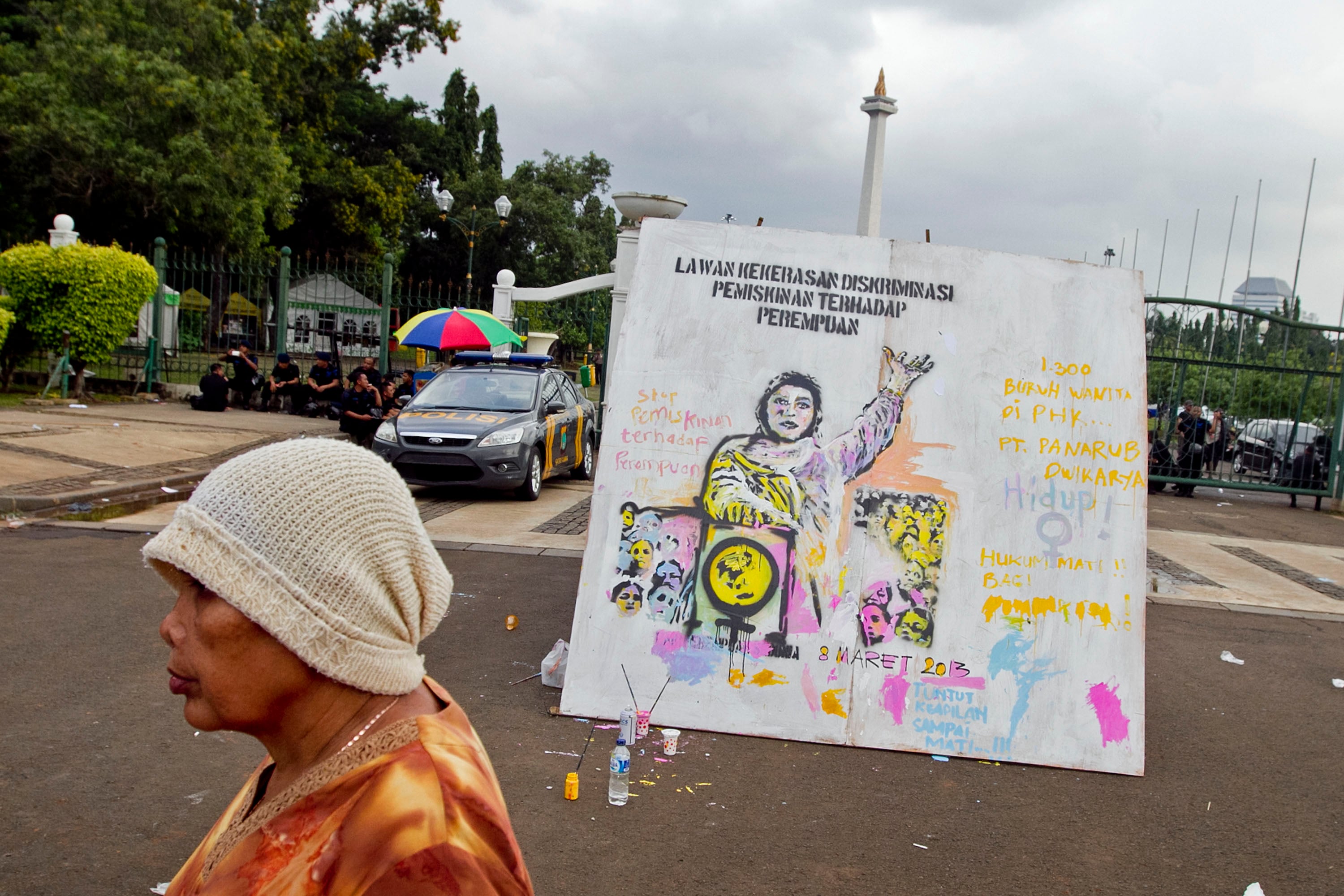 Seorang perempuan melintasi mural terkait aksi protes pada Hari Perempuan Internasional.