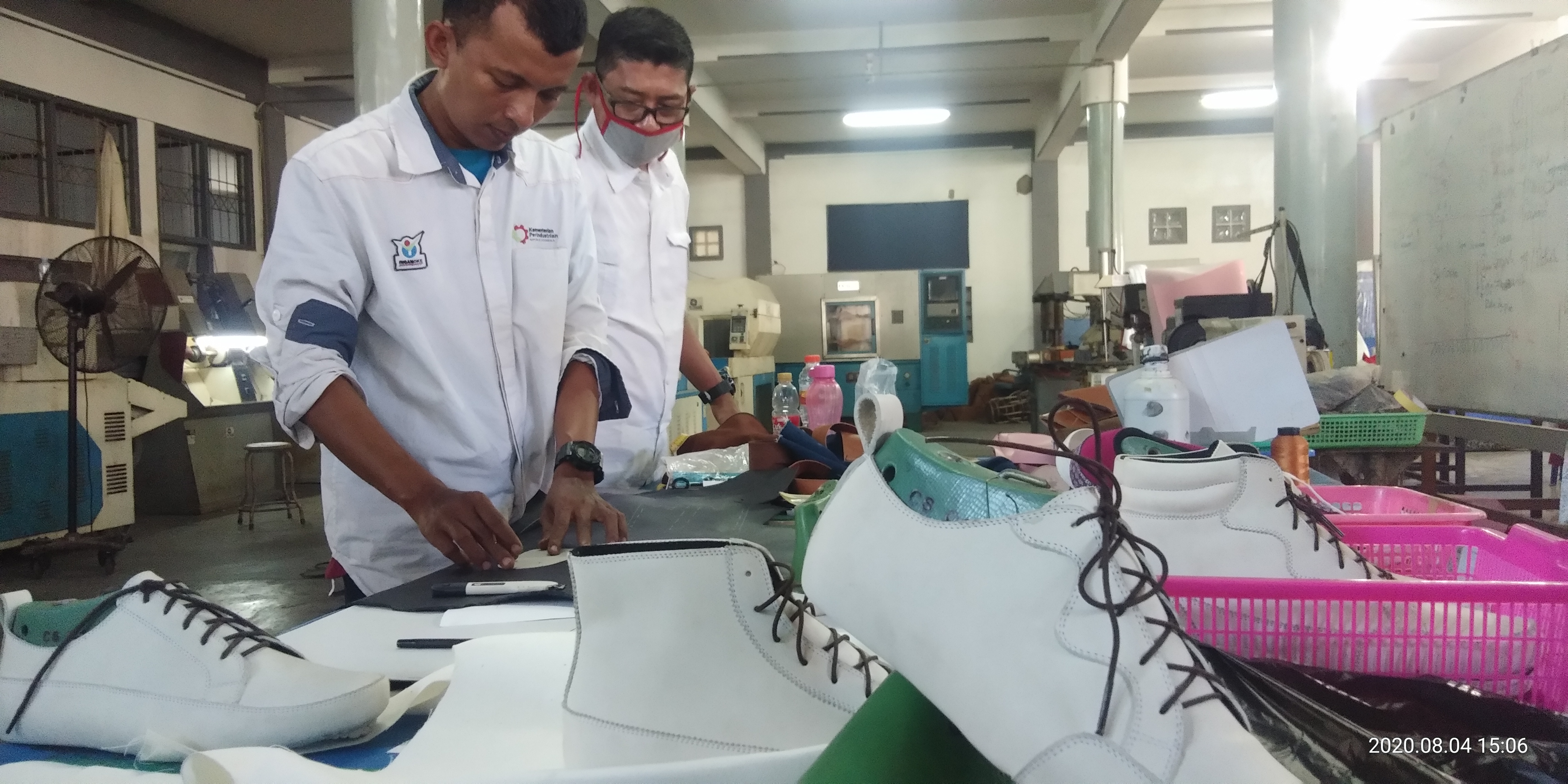 Pekerja tengah menyelesaikan sepatu di sebuah pabrik.