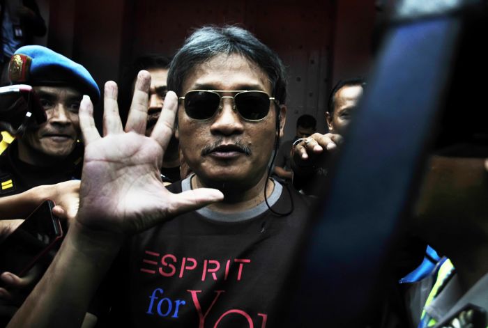 Pollycarpus Budihari Prijanto melambaikan tangan ke arah wartawan saat keluar meninggalkan Lapas Kelas 1 Sukamiskin, Bandung Jawa Barat.  