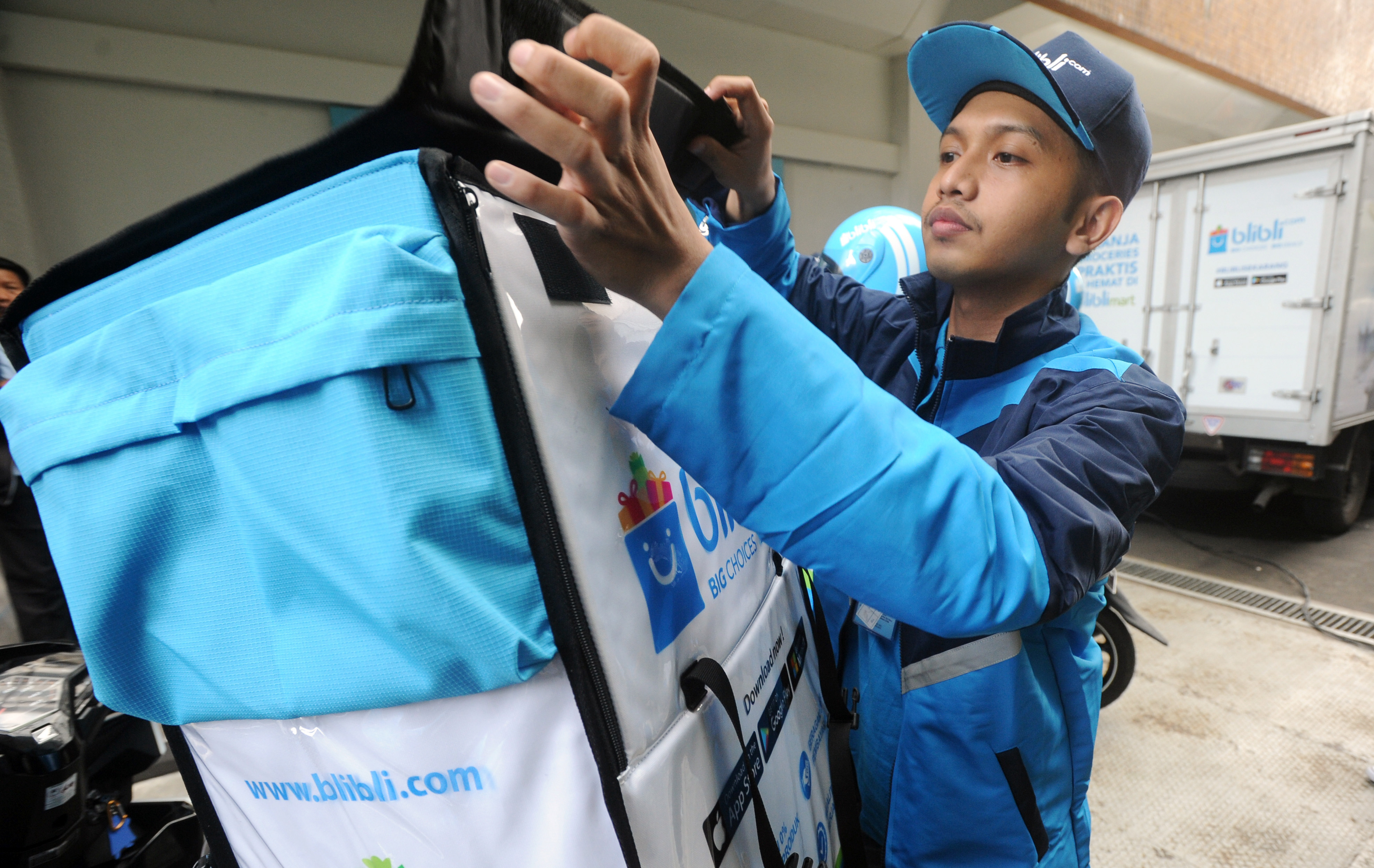 Seorang petugas BlibliMART bersiap mengantarkan barang yang dipesan secara 