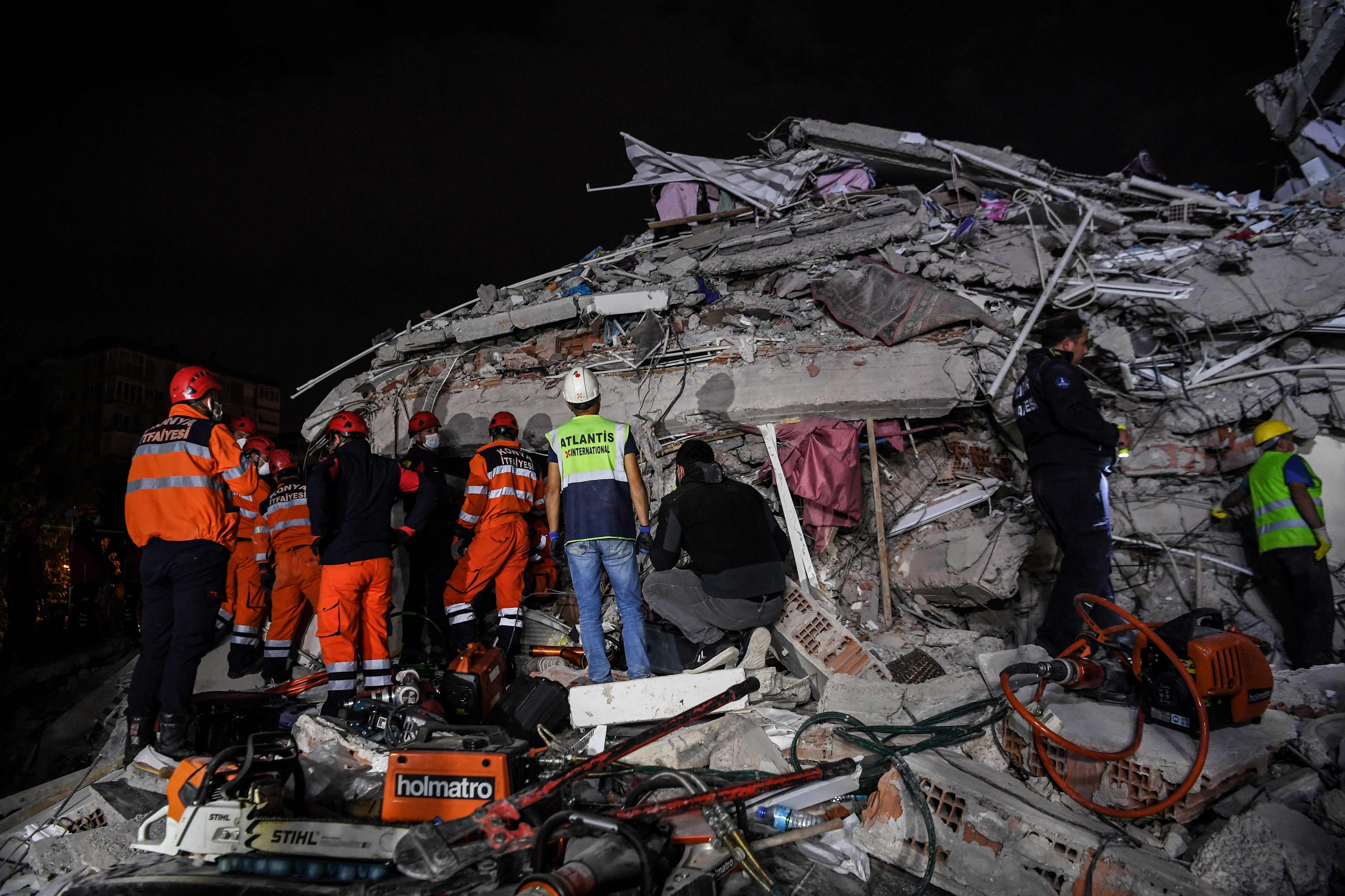 Petugas mengevakuasi korban yang masih terkurung di reruntuhan gedung akibat gempa 7,0 magnitudo di Kota Izmir, Turki, Jumat (30/10/2020).