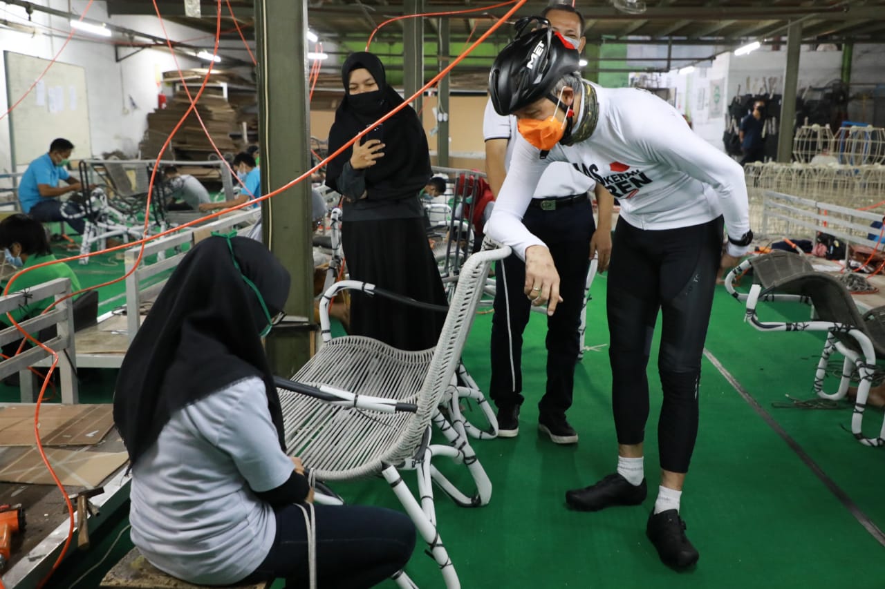 Gubernur Jawa Tengah Ganjar Pranowo (kanan) berbincang dengan pekerja di bengkel mebel Inizio di Kendal.