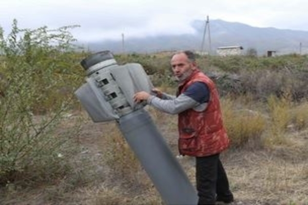 Warga memegang selongsong roket guna pertempuran Armenia - Azerbaijan di Kota Horadiz di Distrik Füzuli, Azerbaijan, kemarin