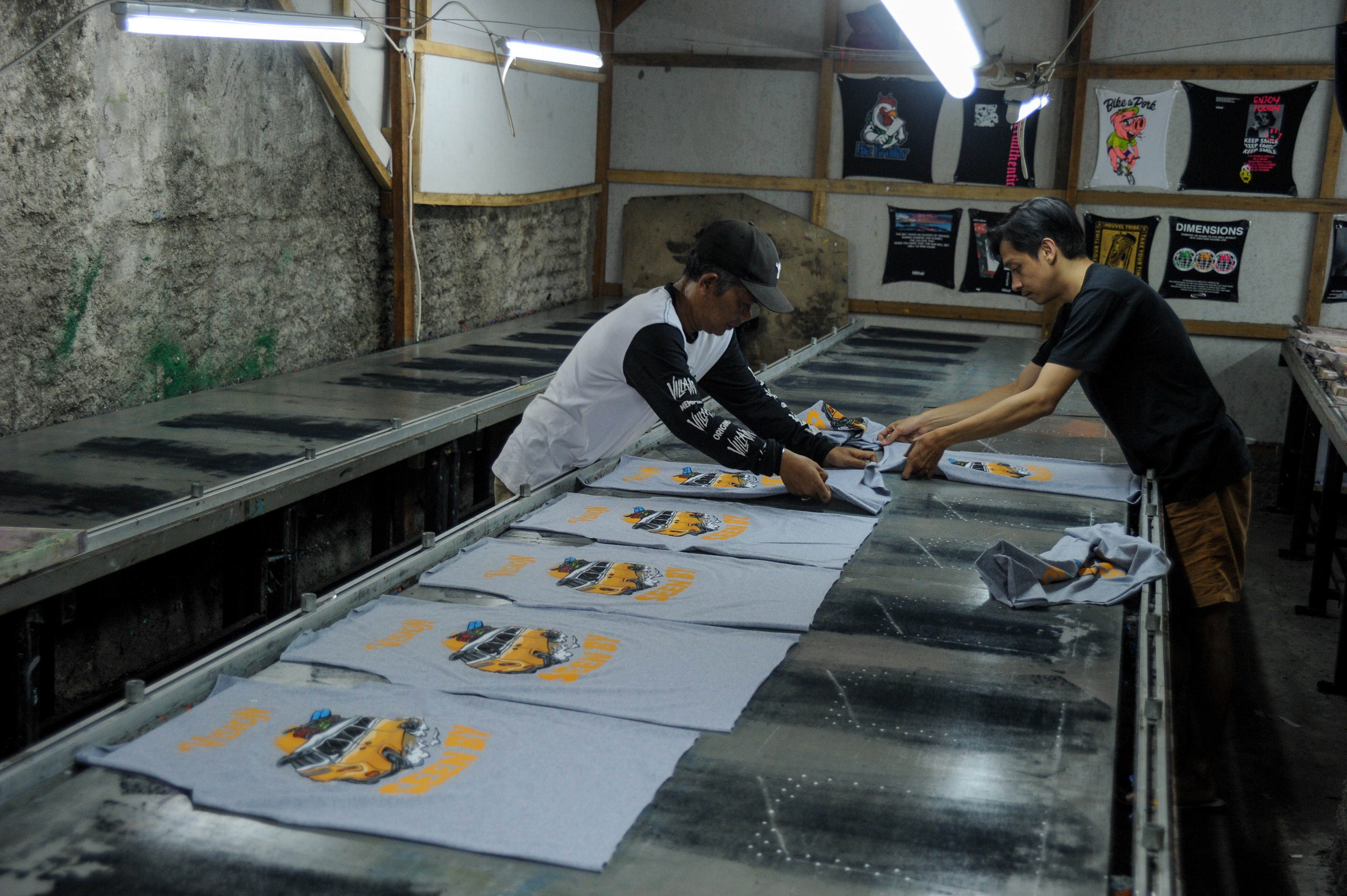 Buruh kerja menyelesaikan produksi pakaian di sebuah perusahaan konveksi di Bandung, Jawa Barat.
