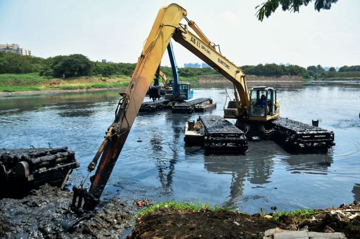 Petugas mengoperasikan alat berat saat pengerukan lumpur di Waduk Ria Rio, Jakarta, Senin, (21/9/2020)