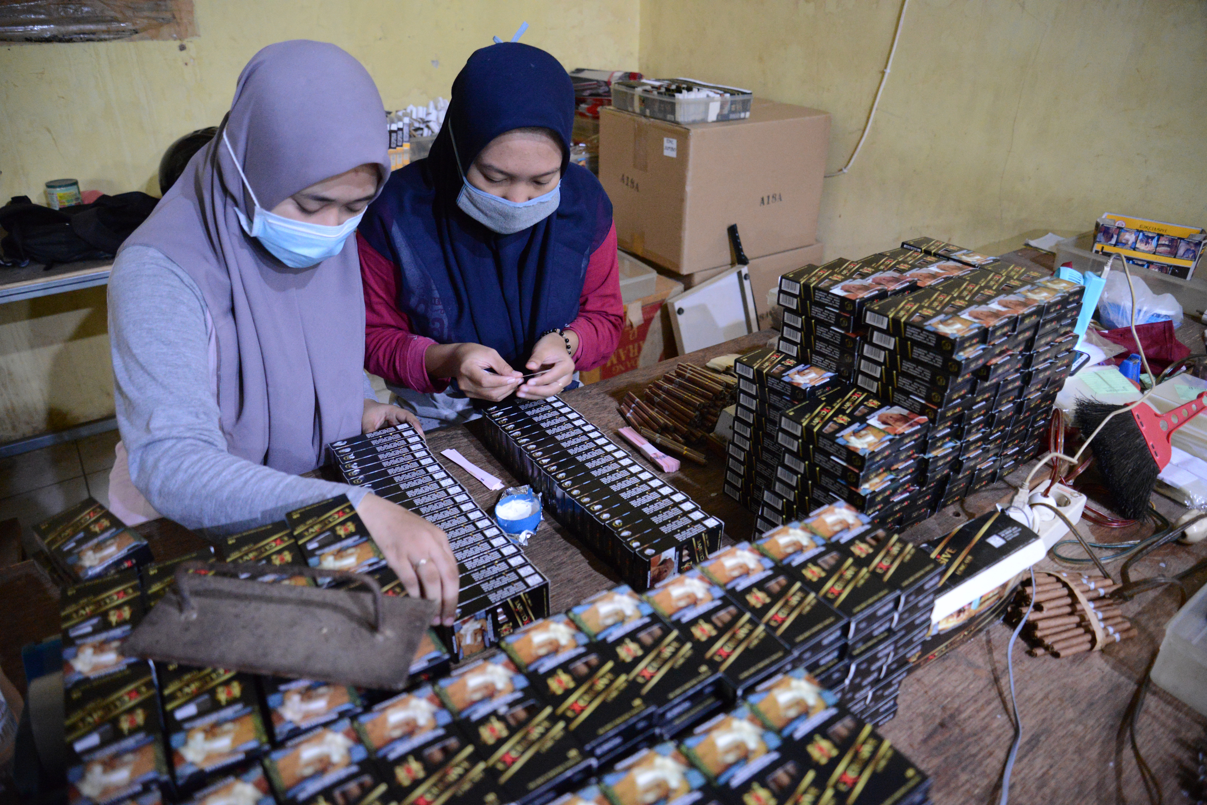 PASCAKENAIKAN CUKAI ROKOK: Pekerja perempuan memasang pita cukai di industri rokok rumahan di Desa Plandi, Kabupaten Jombang, Jawa Timur