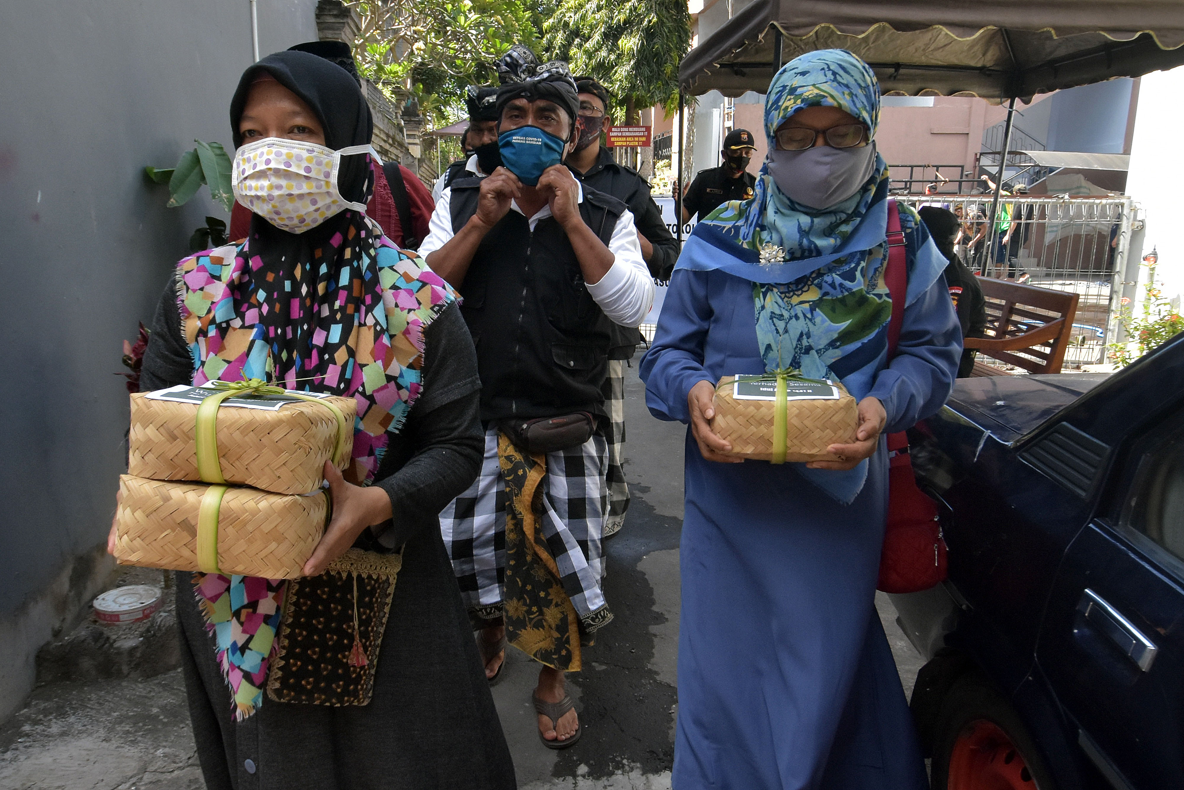 Pecalang (petugas keamanan adat) mendampingi umat Islam mengantar daging kurban Idul Adha untuk warga umat Hindu di Denpasar, Jumat (31/7).