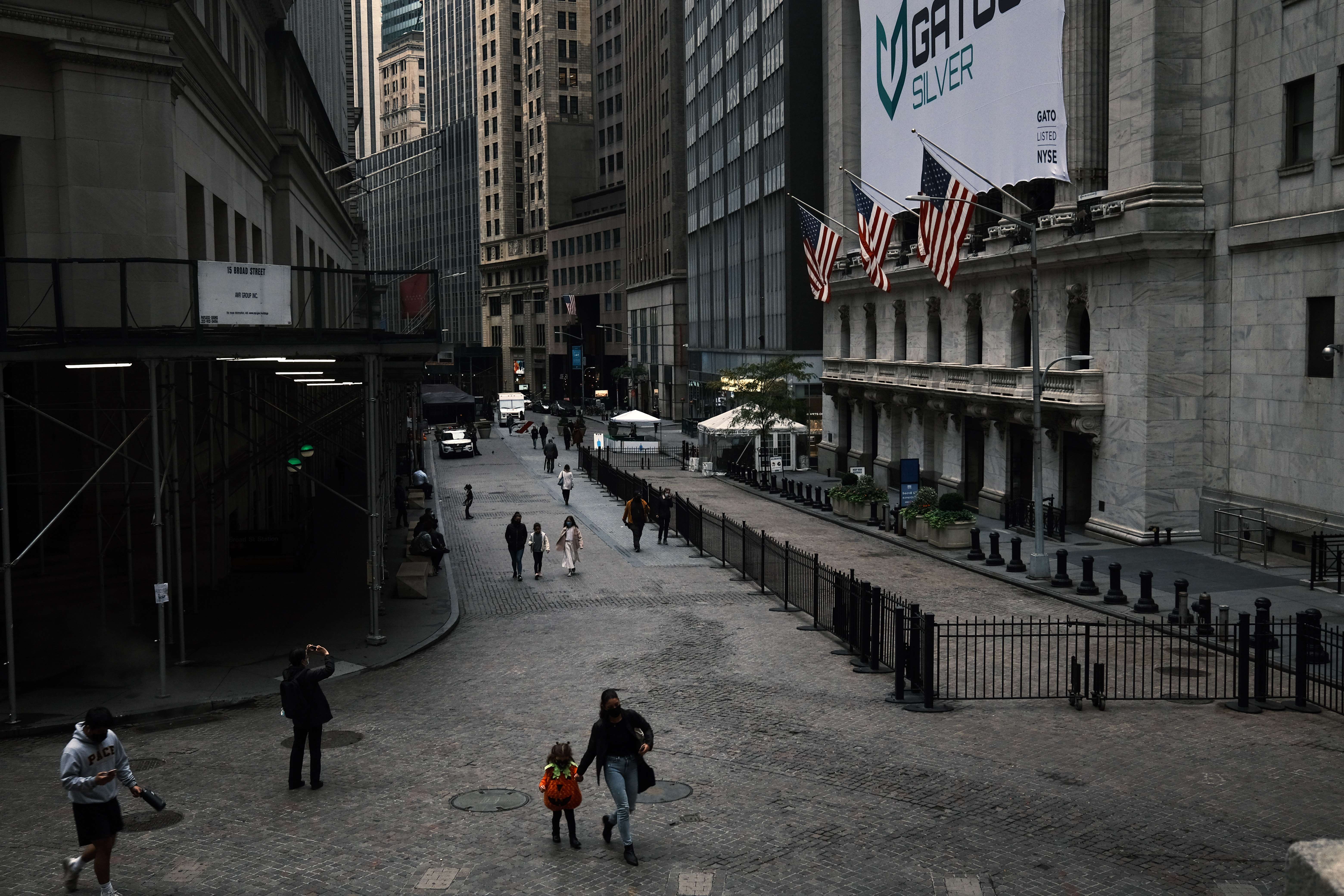 Sejumlah warga berjalan di depan Gedung Bursa Saham New York, Wall Street, Kamis (28/10/2020).