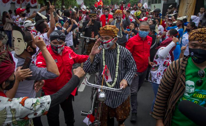 Pendaftaran paslon pilkada yang diiringi dengan arak-arakan tanpa protokol kesehatan. 