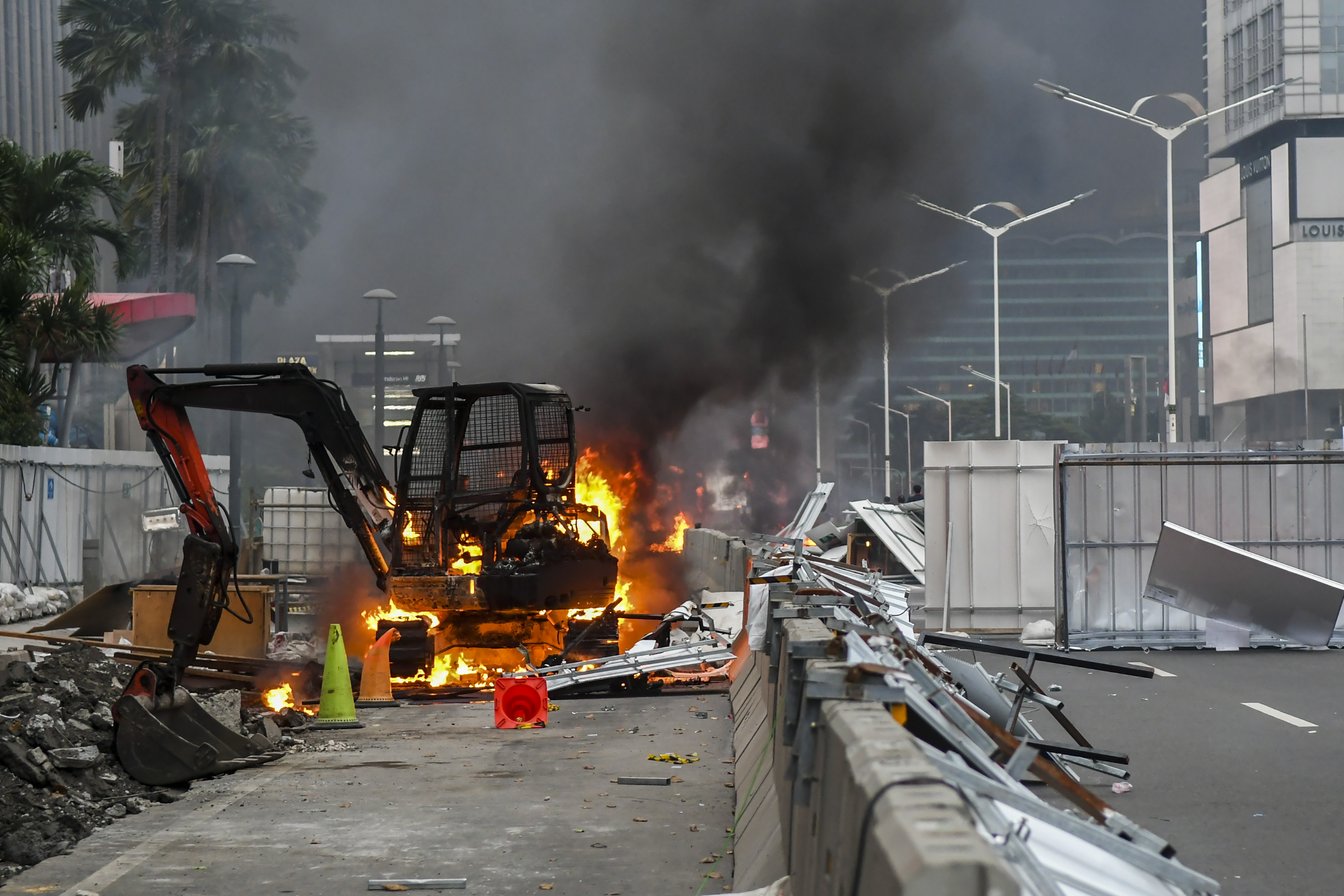Alat berat terbakar saat bentrokan pengunjuk rasa dengan polisi pada demo menentang UU Cipta Kerja di Jakarta, Kamis (8/10).