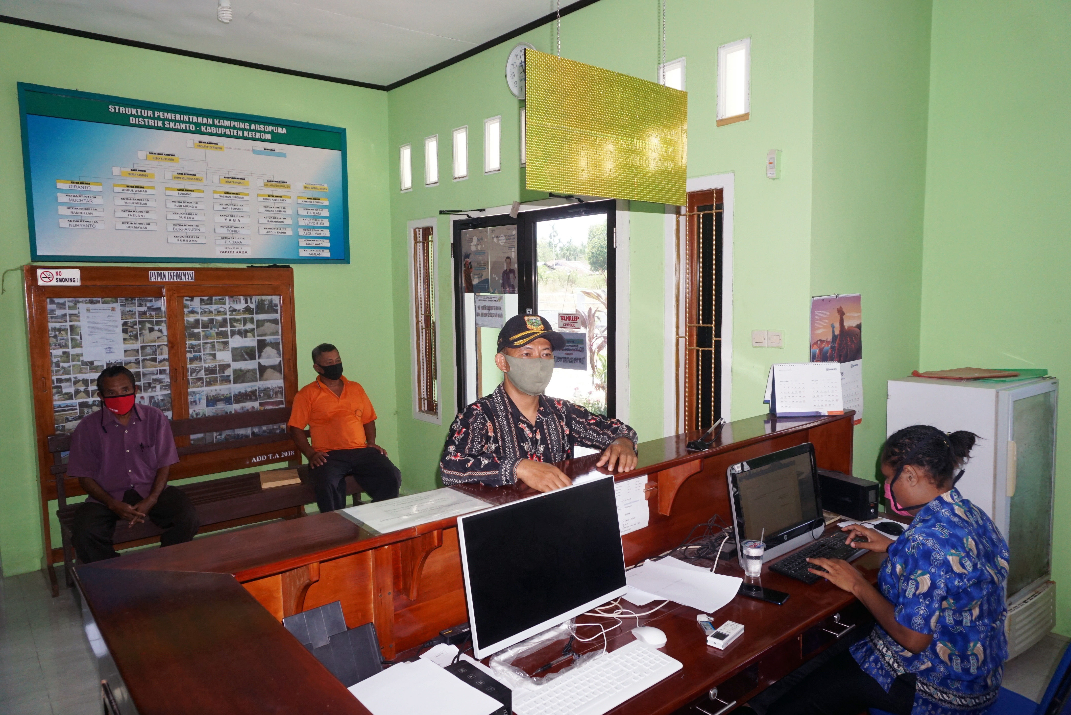 Seorang petugas memakaai masker melayani warga di Kantor Desa Arsopura, Distrik Skanto, Kabupaten Keerom, Papua, Kamis (8/10). 