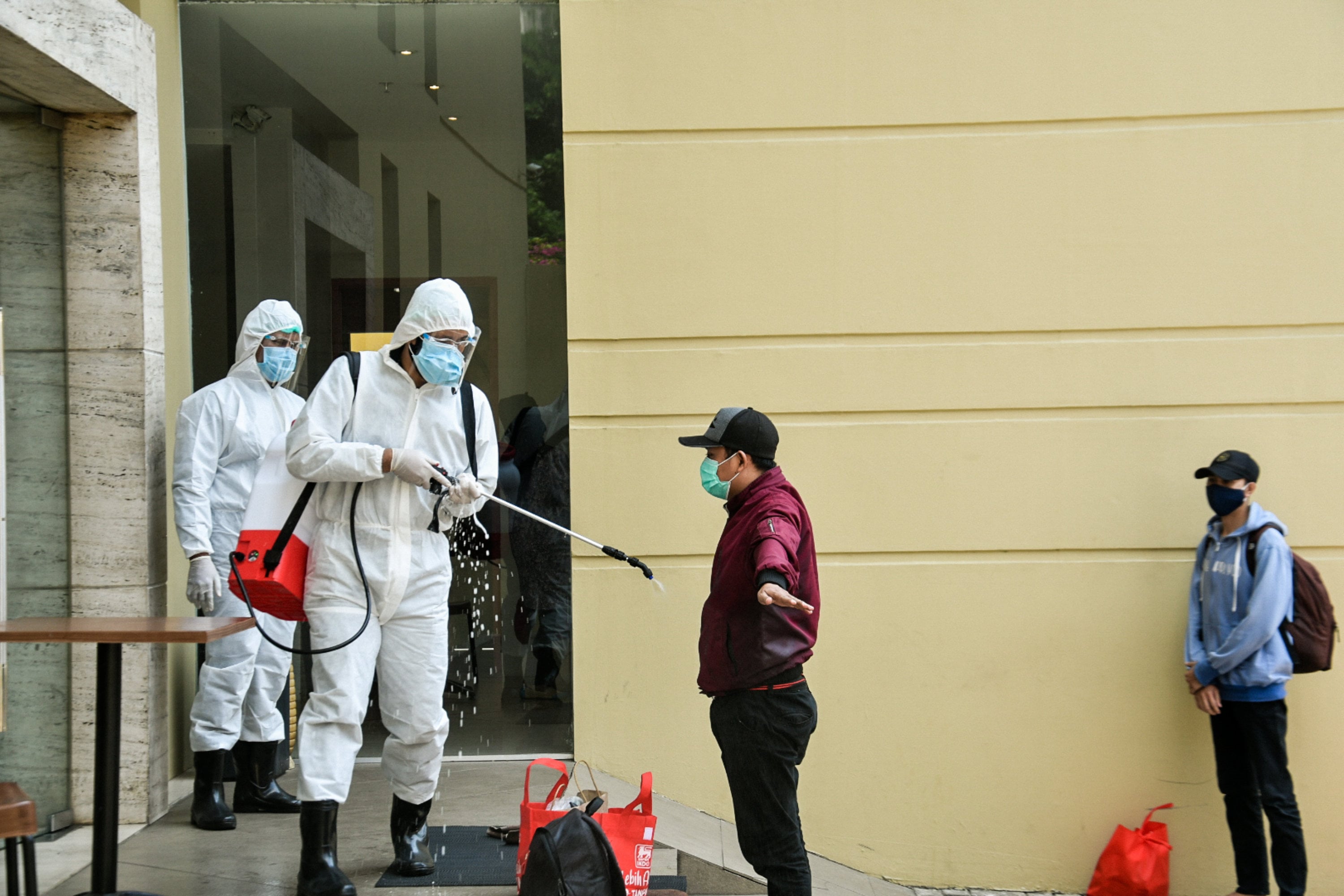 Petugas medis menyemprotkan cairan disinfektan kepada pasien OTG covid-19 untuk di isolasi mandiri di Hotel U Stay, Mangga Besar, Jakarta.