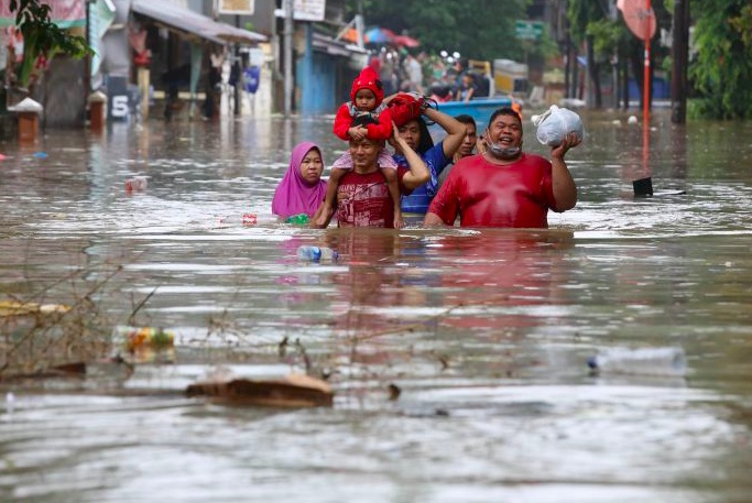 Warga menyelamatkan diri saat banjir melanda kawasan Bendungan Hilir, Jakarta.