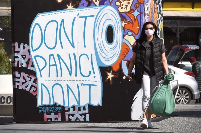 Wanita berjalan melewati mural di Melbourne pada 10 September 2020.