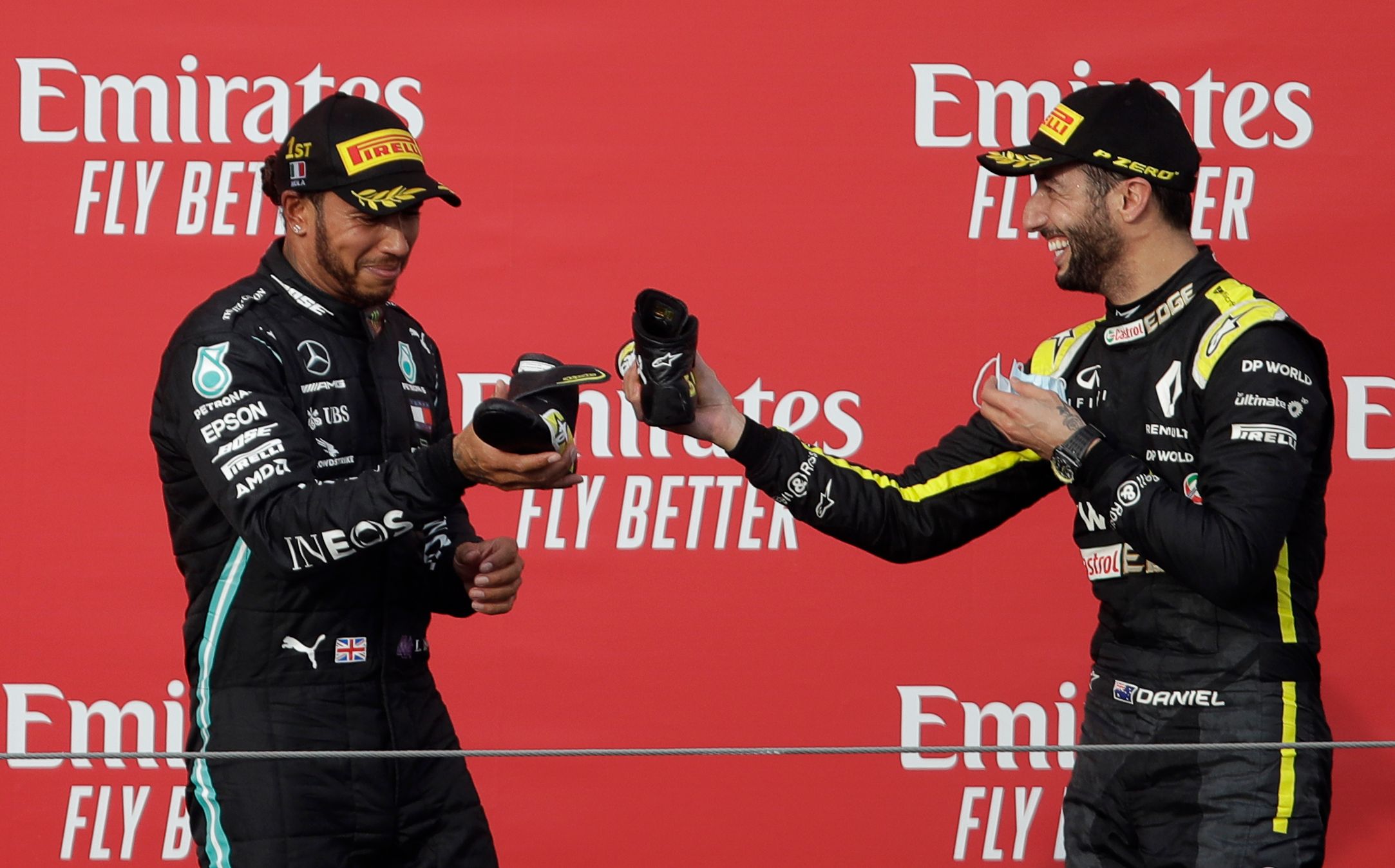 Lewis Hamilton dan Daniel Ricciardo melakukan selebrasi shoey di podium GP Emilia Romagna.