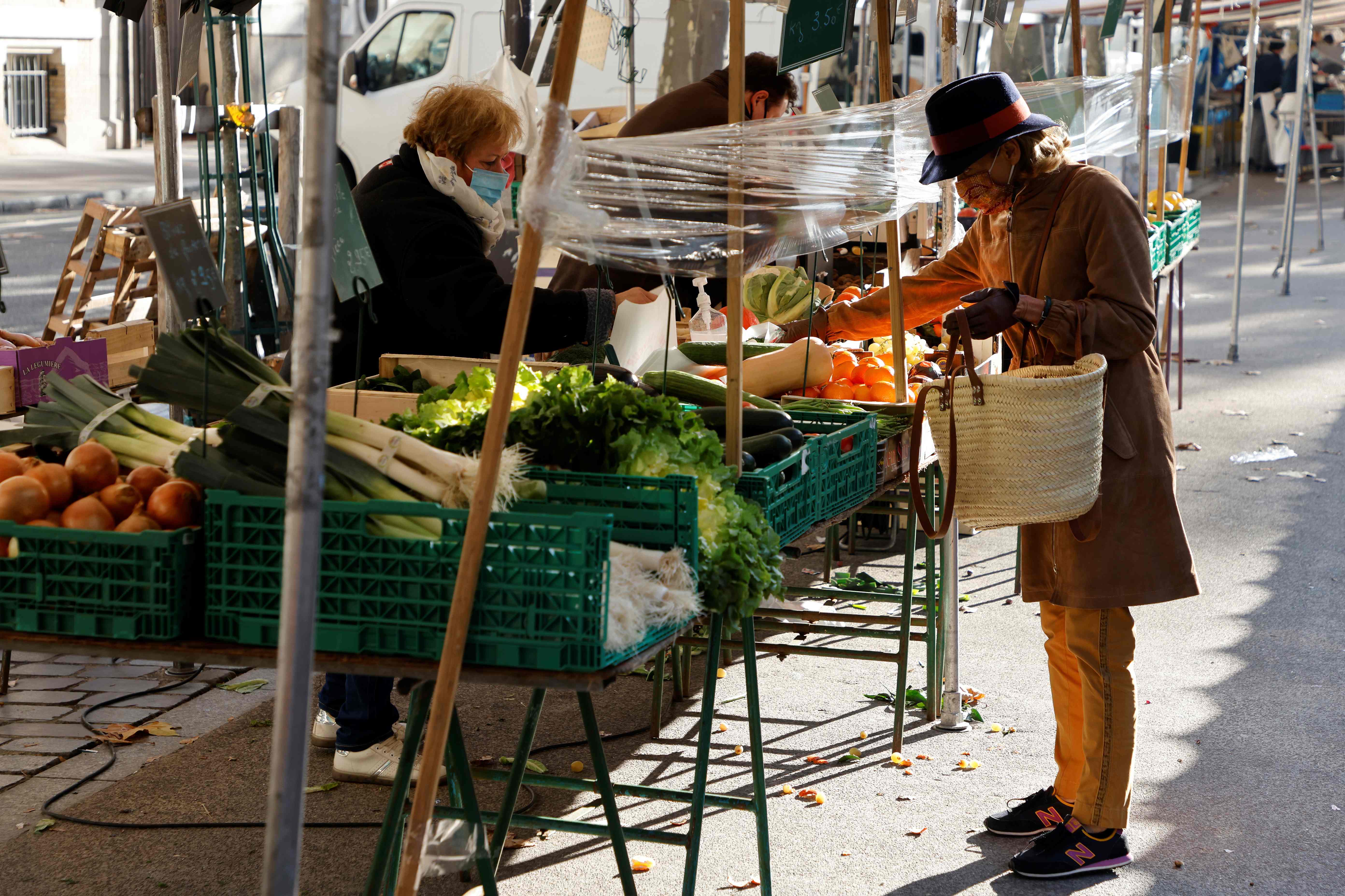 Warga mengenakan masker berbelanja di sebuah pasar terbuka di Paris, Prancis.