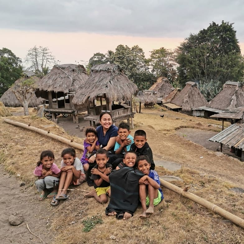 Anak-anak berfoto di depan  Kampung Adat Maghilewa di Desa Inerie, Kecamatan Inerie, Kabupaten Ngada, NTT.