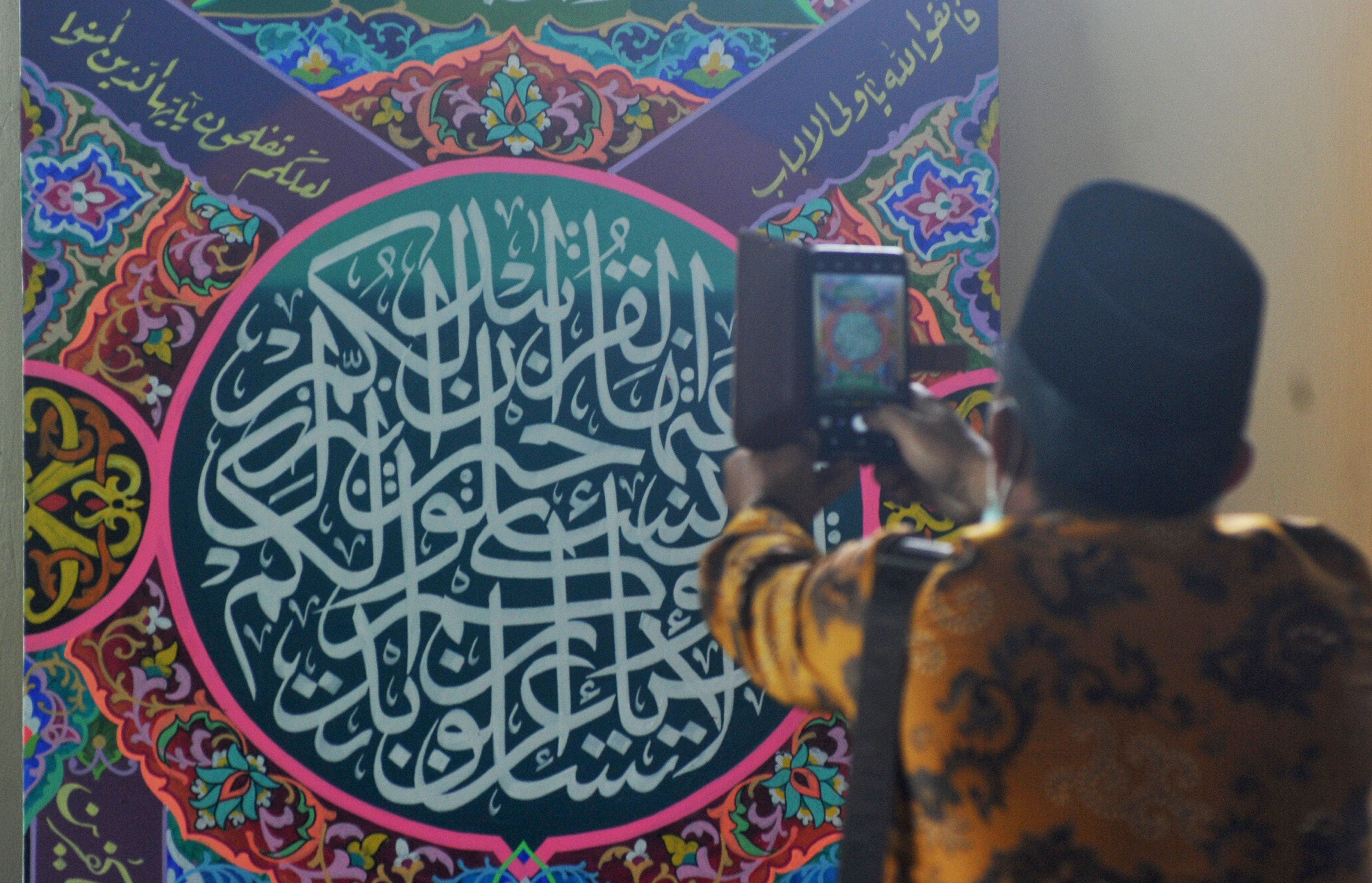 Pengunjung memotret hasil karya Lomba Cabang Khat (Kaligrafi) Al Quran, MTQ Nasional ke-28, di GOR UNP, Padang, Sumbar, Selasa (17/11).