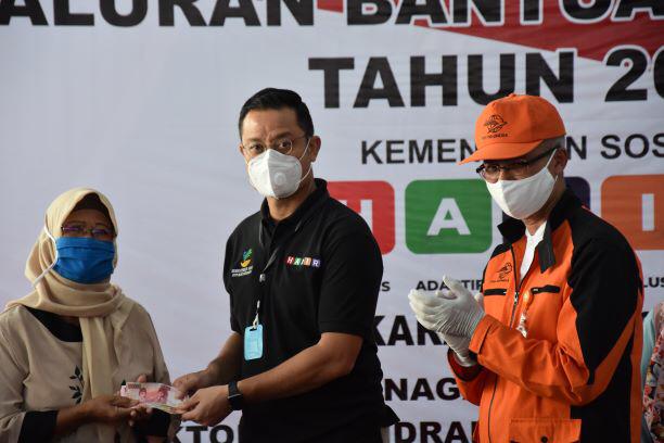Menteri Sosial Juliari Batubara (tengah) saat memberikan bantuan sosial tunai bekerja sama dengan PT Pos Indonesia di Kabupaten Karawang.