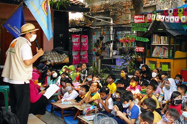 Pendongeng Adi Pamungkas (kiri) saat mendongeng di hadapan anak-anak warga Cakung Barat, Jakarta Timur, kemarin.