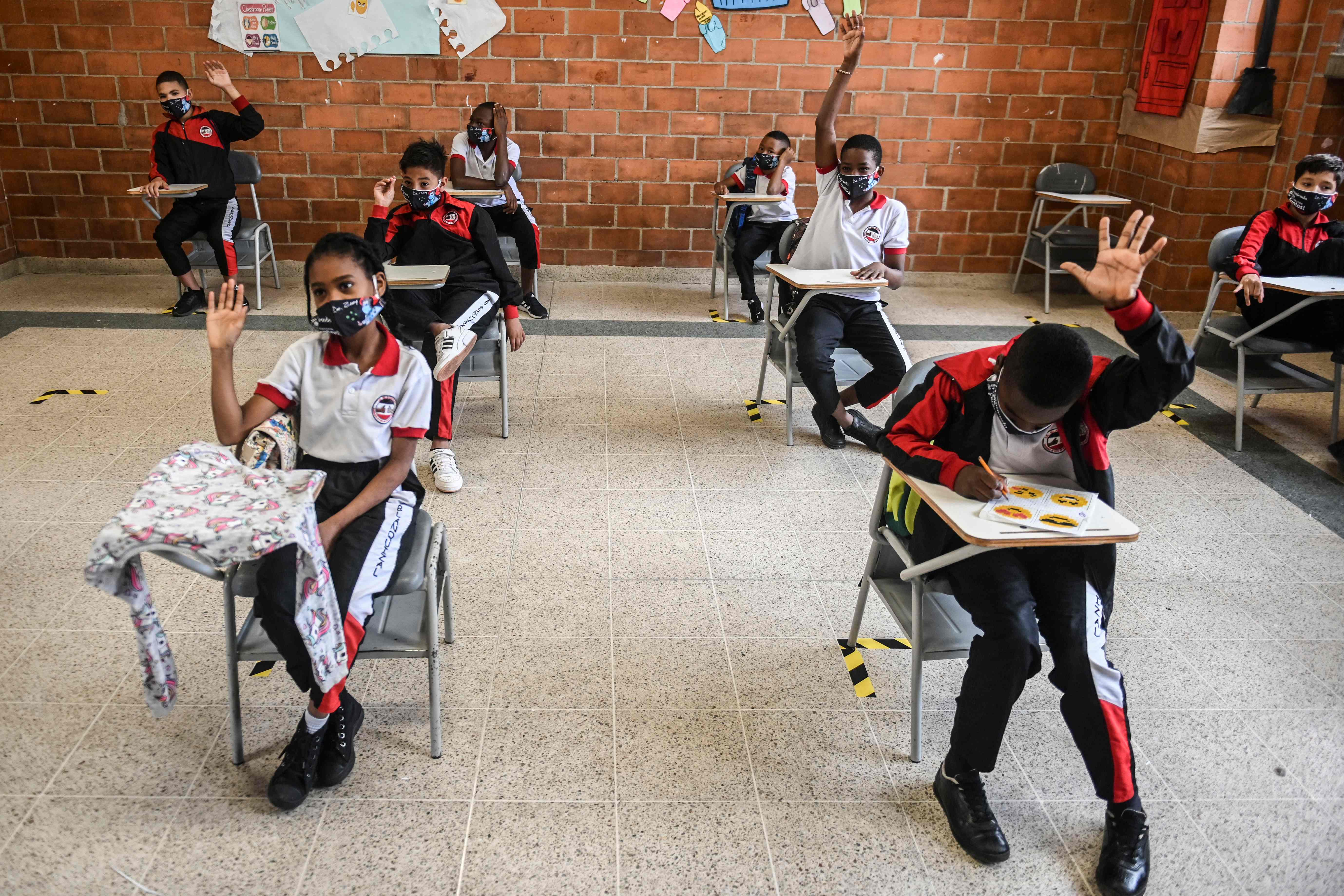 Pelajar mengenakan masker saat mengikuti kegiatan belajar di sekolah negeri Blanquizal di Medellin, Kolombia.