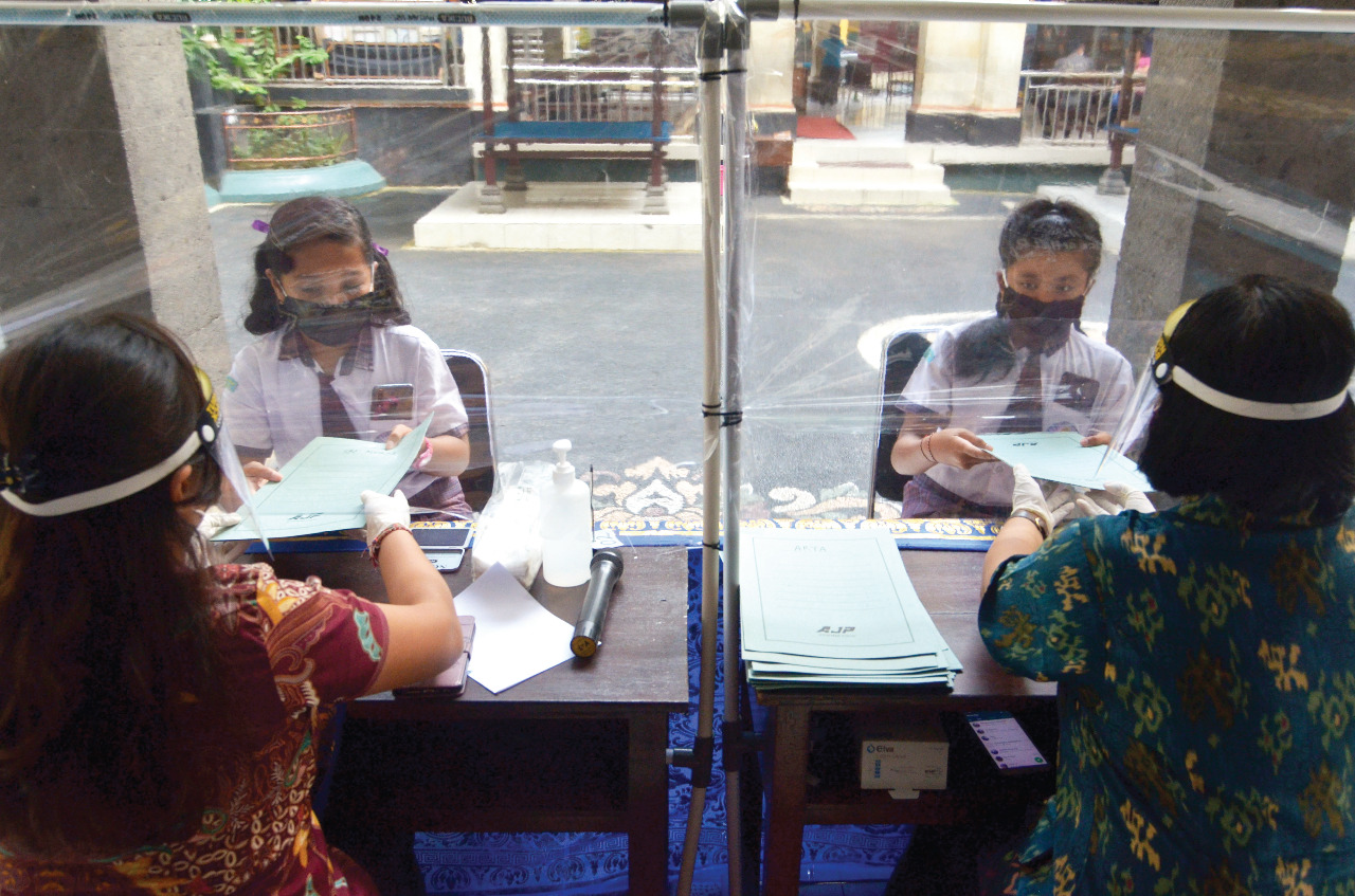 Guru menyerahkan dokumen kelulusan bagi siswa kelas VI di SD Widiatmika, Jimbaran, Badung, Bali, Kamis (18/6/Q0Q0).