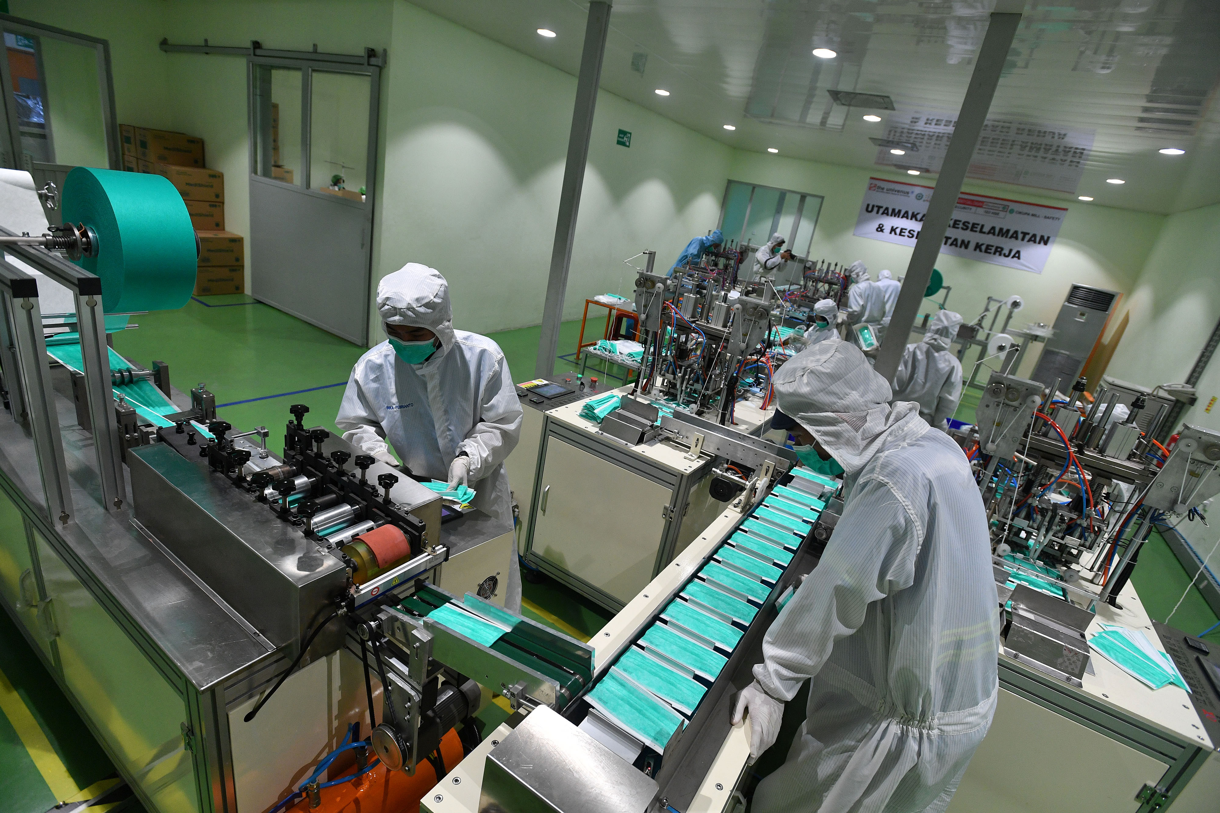Ilustrasi: pekerja memantau masker bedah yang diproduksi